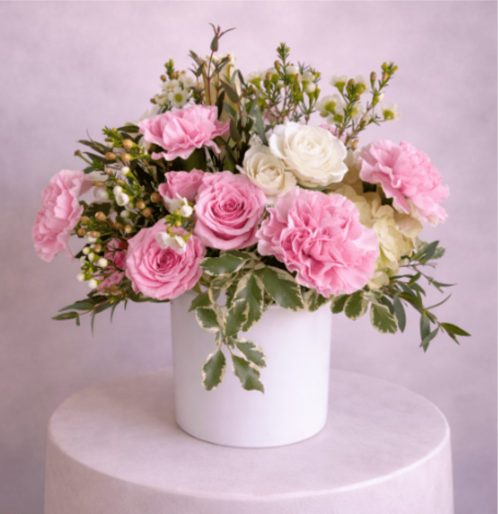 Pink and white rose bouquet in a white vase