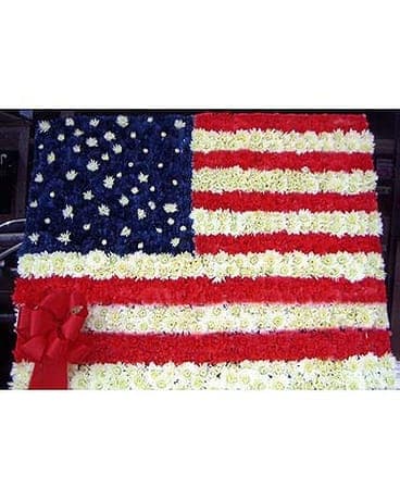Floral arrangement shaped like the American flag with red, white, and blue flowers