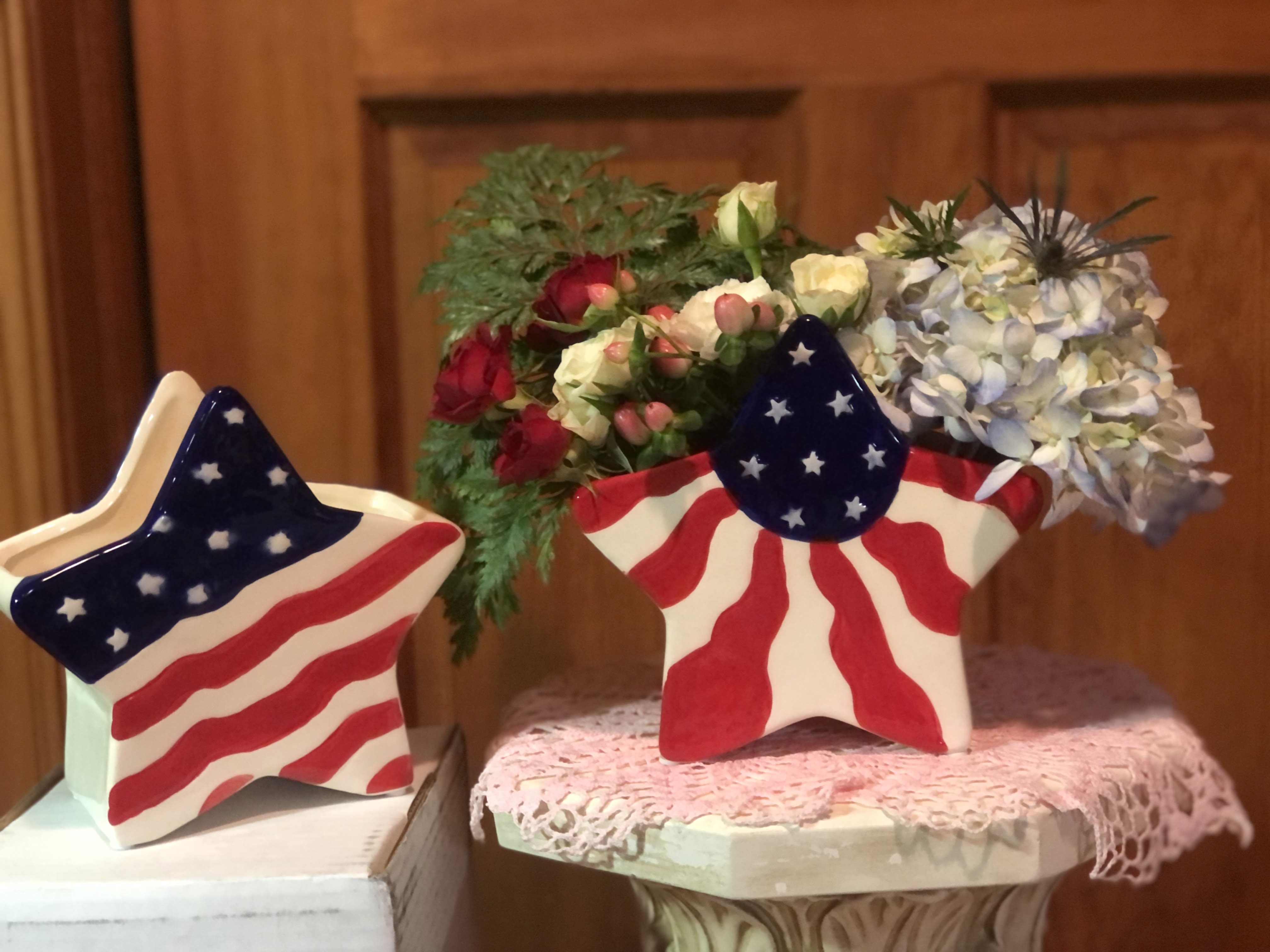 Star-shaped patriotic flower arrangements in painted ceramic containers