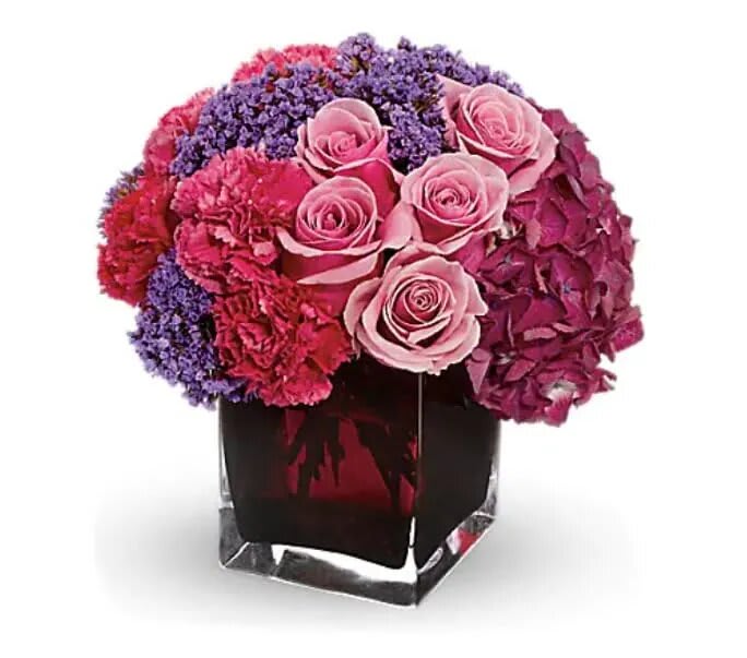 Enchanted Journey - Romance that stands all the tests of time is like an enchanted journey. This beautiful arrangement is a wonderful way to celebrate that love. Gorgeous dark pink hydrangea, pink roses and carnations, plus lavender statice are lovingly arranged in an exclusive plum-colored cube vase. 