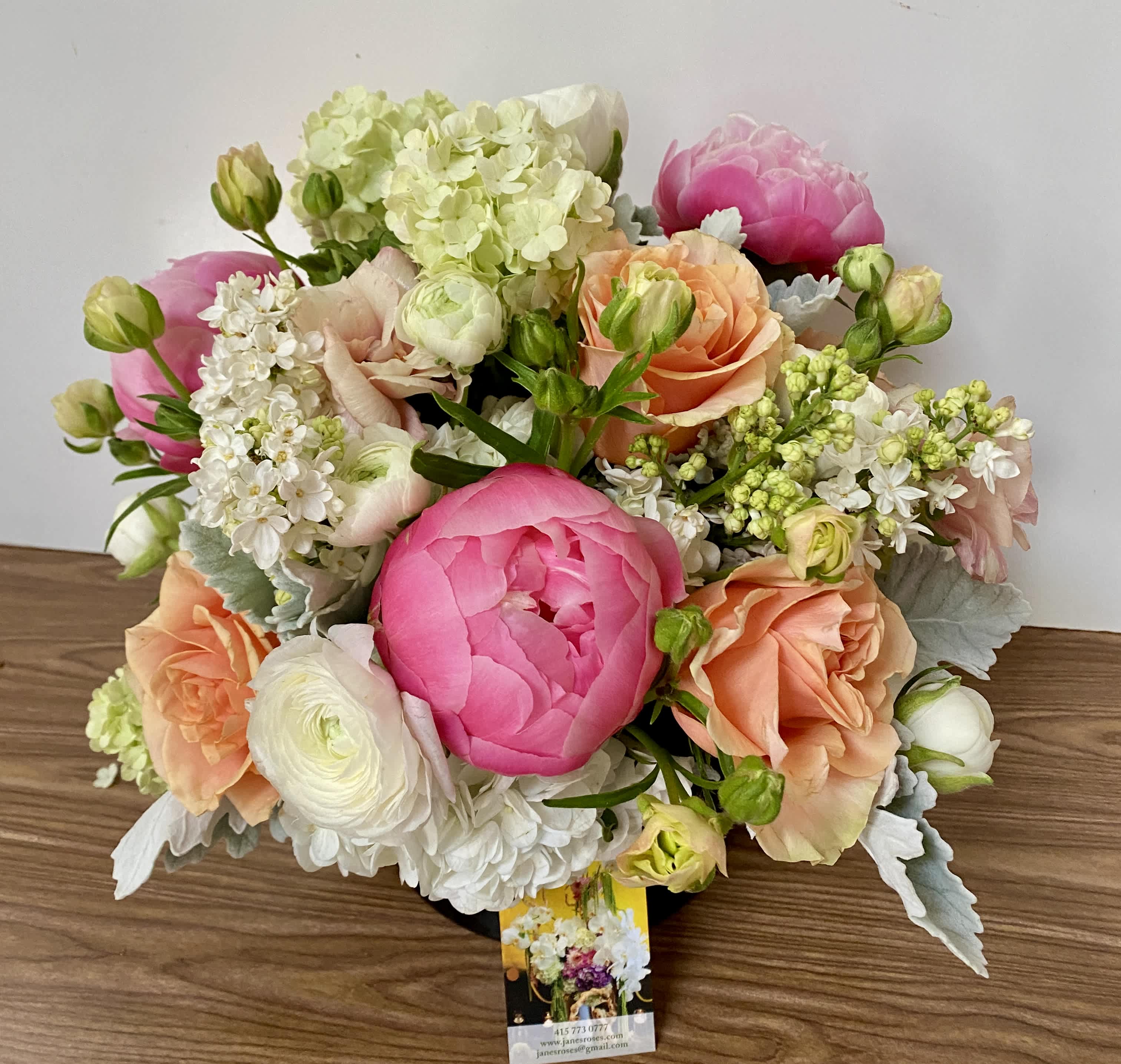 Bouquet of pink, peach, and white flowers in a low arrangement