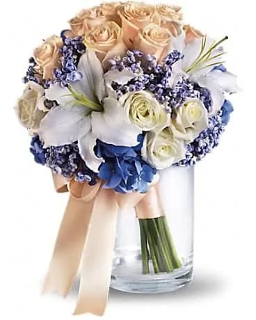 Nantucket Dreams Bouquet - Evoke the soft splendor of the sea with this beautiful upscale bouquet of hydrangea, roses and lilies. Blue hydrangea and white lilies combine beautifully with crÃ¨me and white roses. 