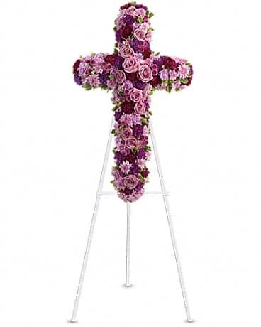 Purple and pink floral cross on a white stand