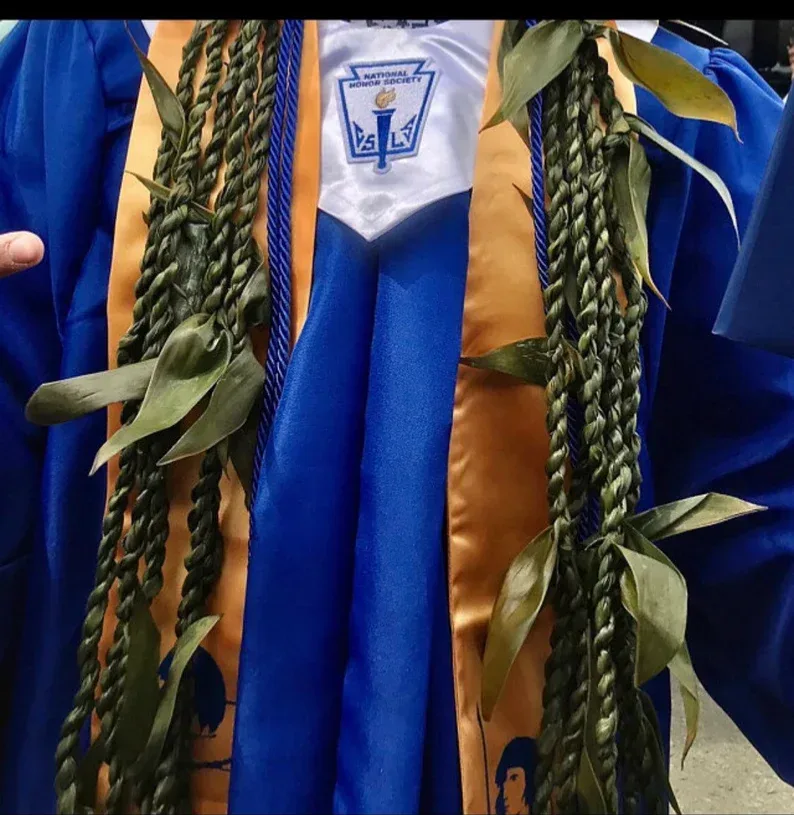 Graduation gown with braided green leis and honor cords