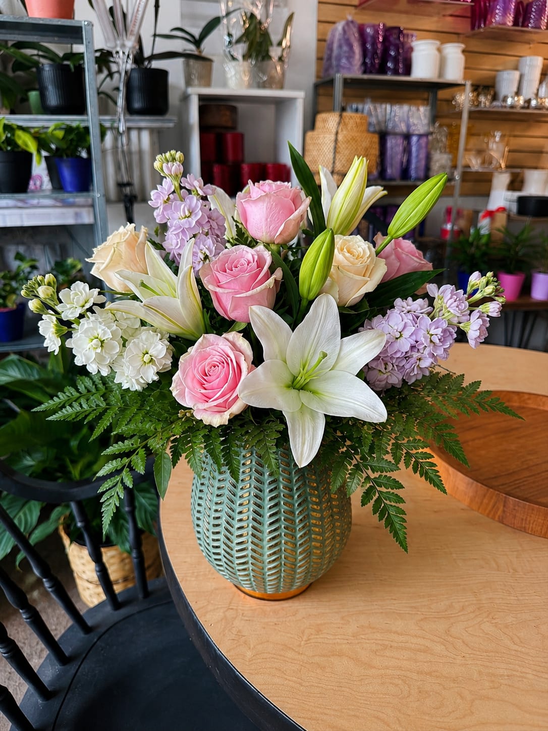 Softly Spoken - Soft, romantic tones of pink, cream, and lavender make this flower arrangement an ideal birthday bouquet, anniversary gift, or thoughtful surprise for spring celebrations. The recipient will feel gently celebrated by the layered mix of roses and lilies-classic, fragrant focal flowers-softened by clusters of purple stock for texture and a whisper of sweet scent.