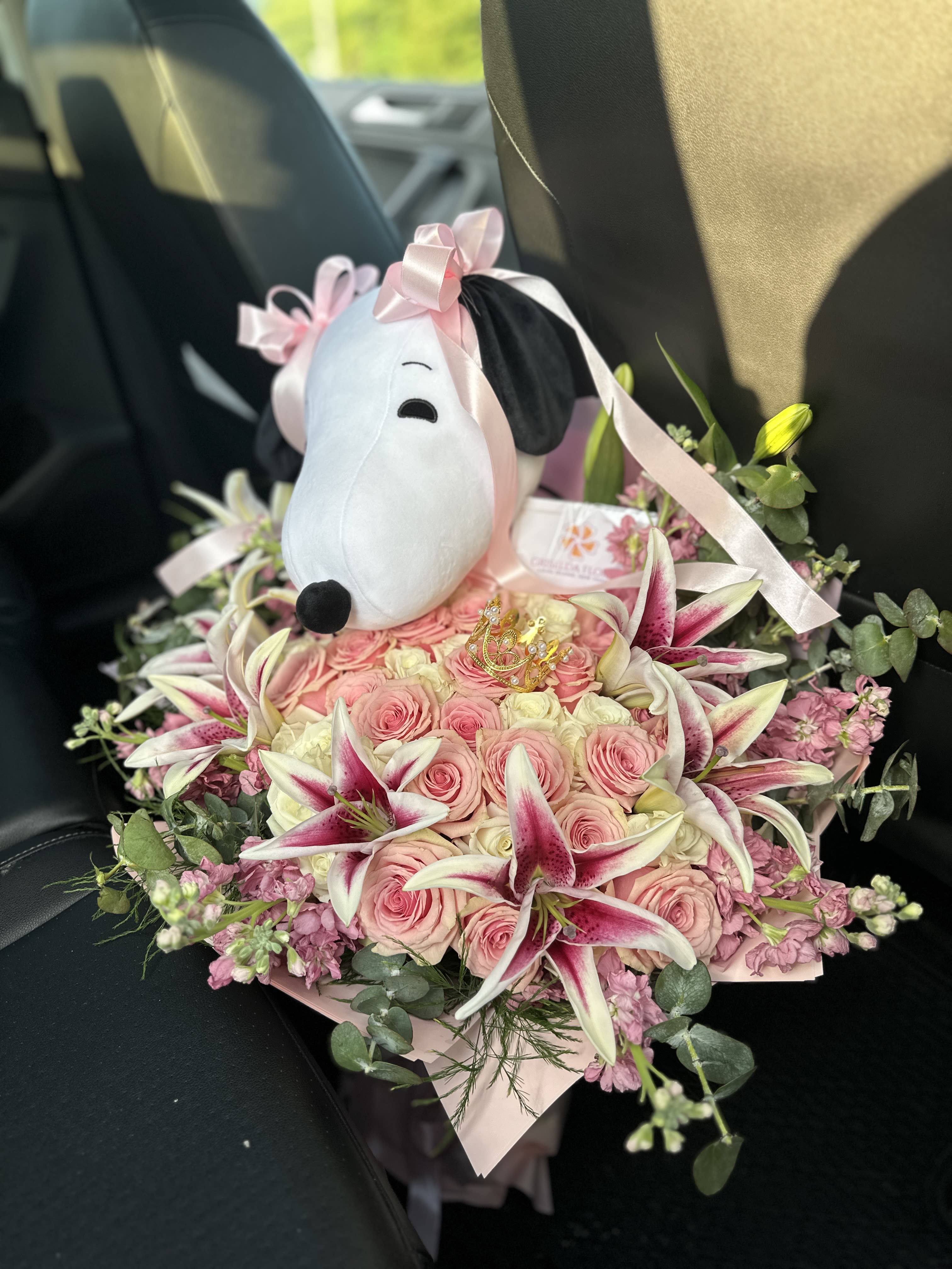Pink rose bouquet with lilies and a Snoopy plush topper