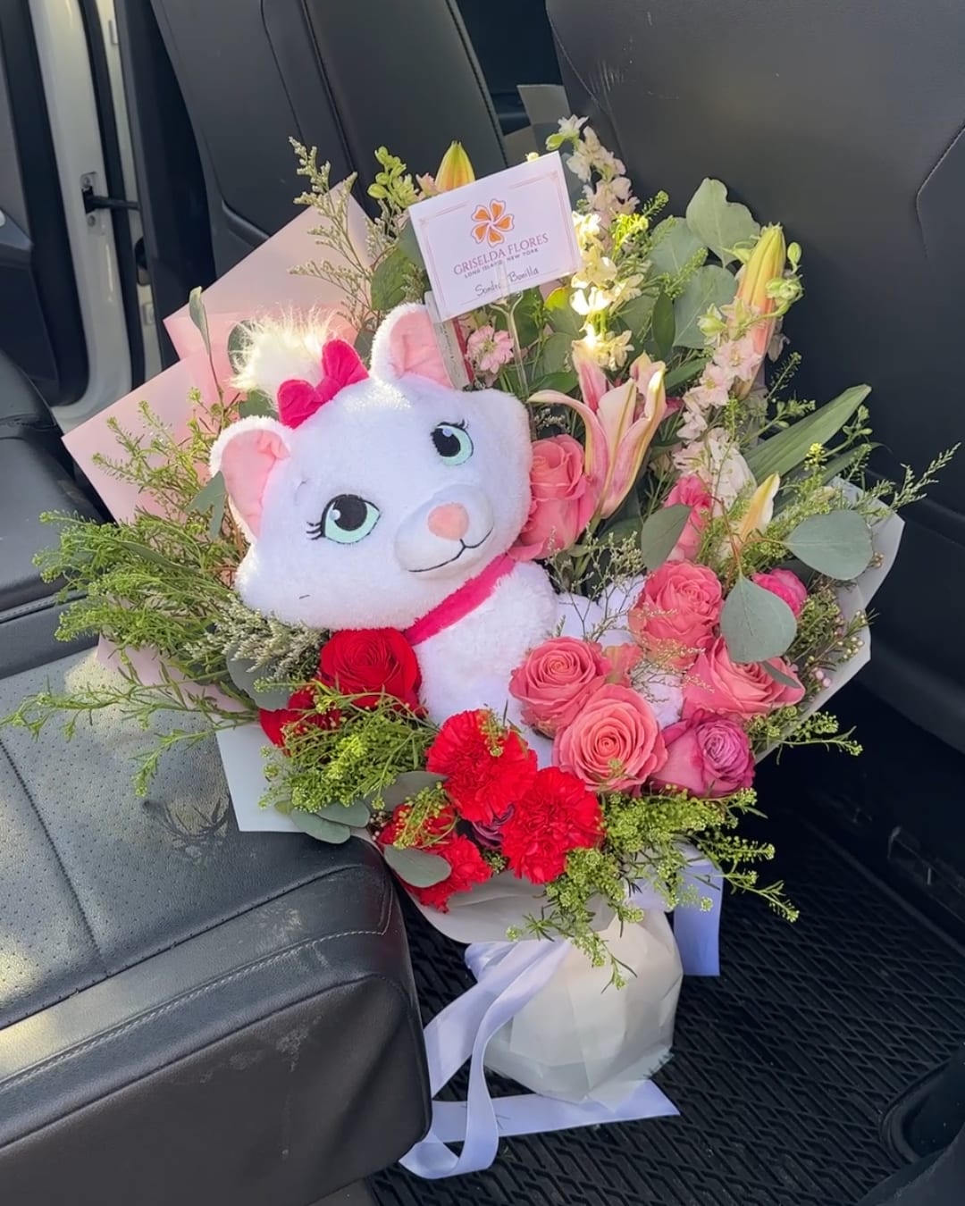 Bouquet of pink roses and lilies with a plush cat toy