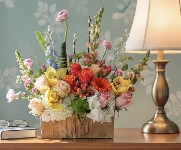 Mixed bouquet in a wooden box with roses and orchids