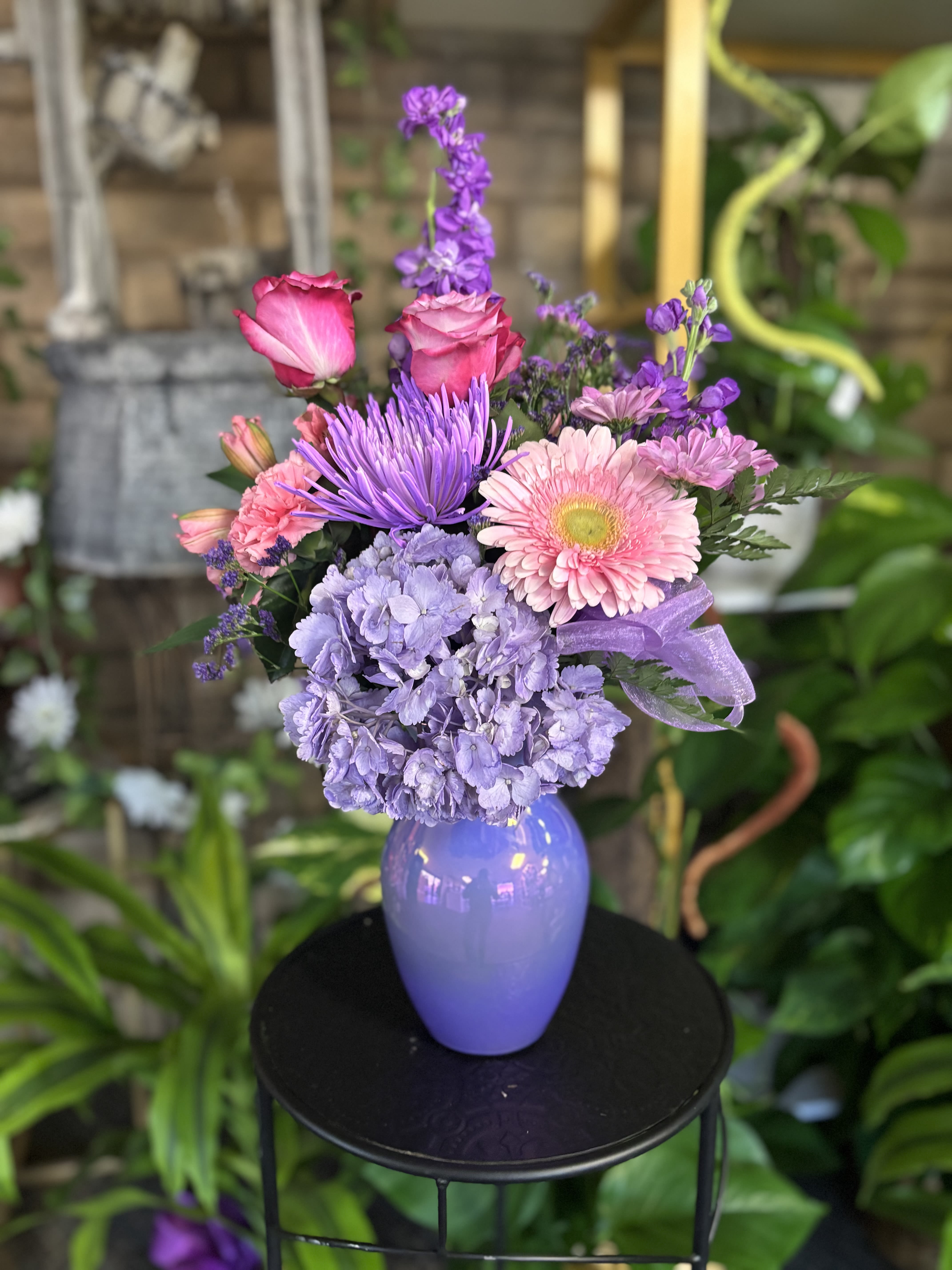 Purple and pink mixed bouquet in a lavender vase