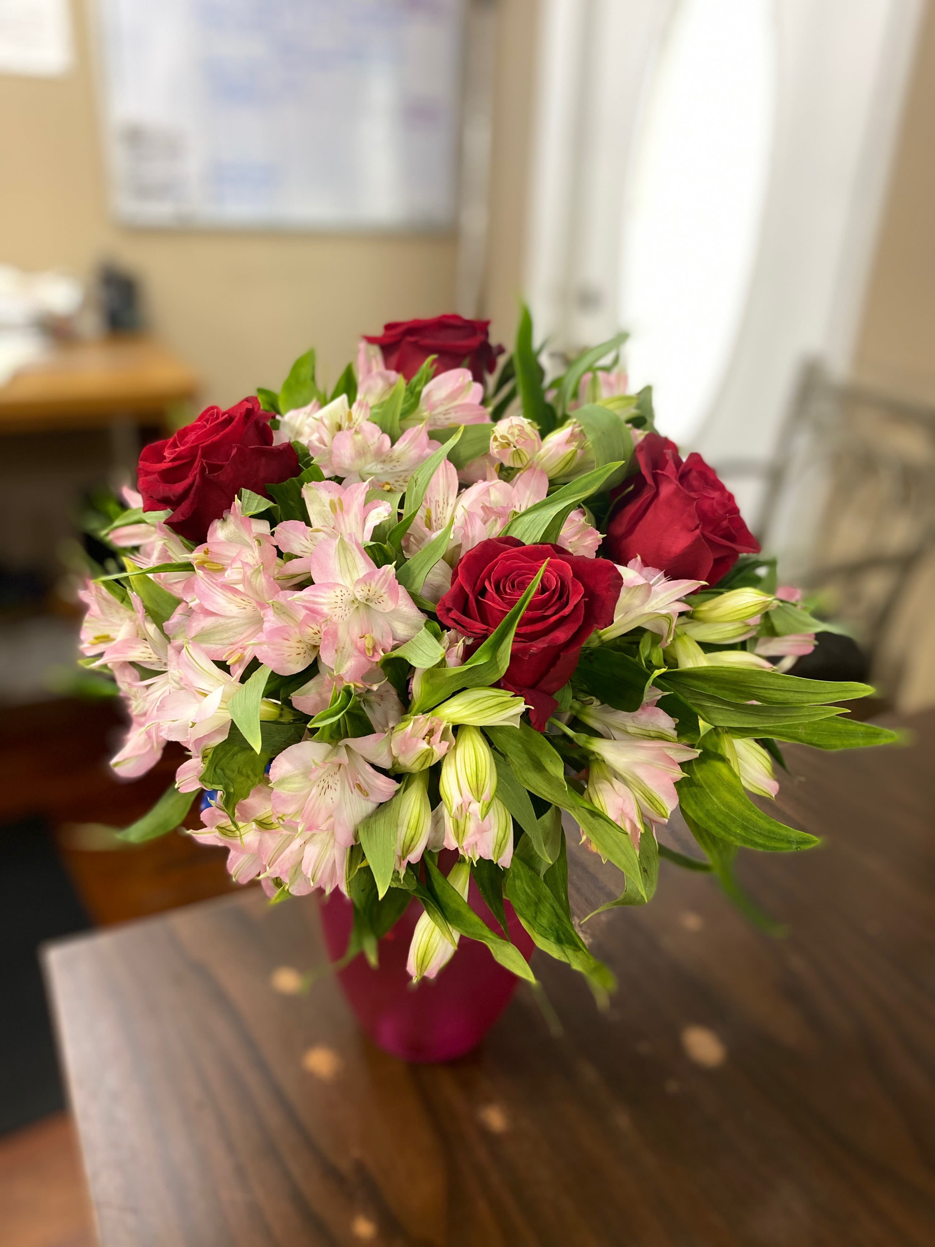Bouquet of red roses and pale pink alstroemeria in a vase