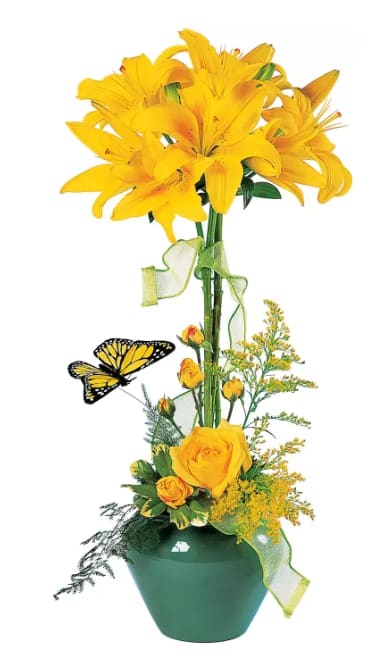 Yellow lilies and roses in a green vase with a butterfly accent