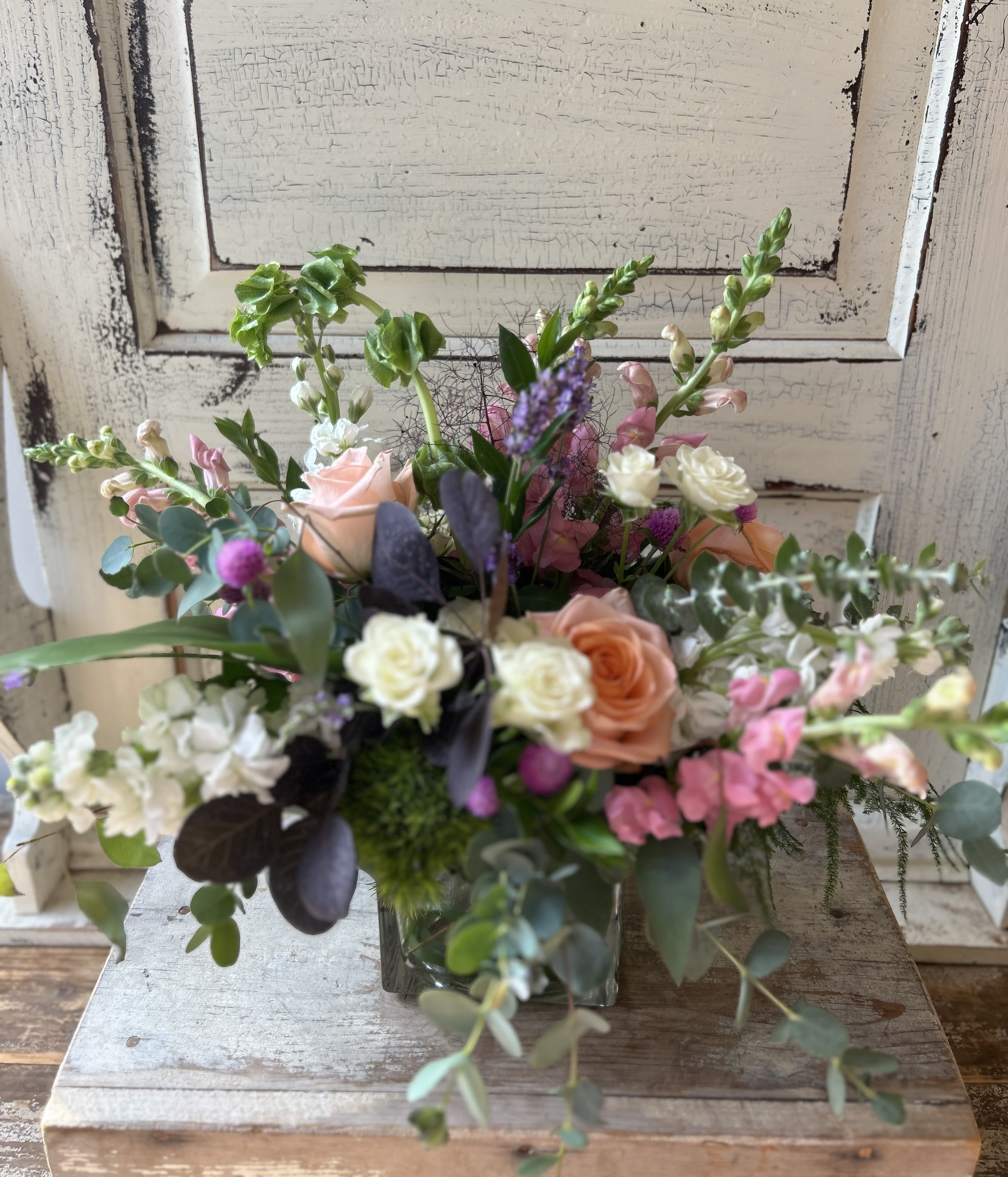 Mixed bouquet in a glass vase with pink, peach, and white flowers