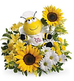 Bee plush surrounded by sunflowers and white daisies
