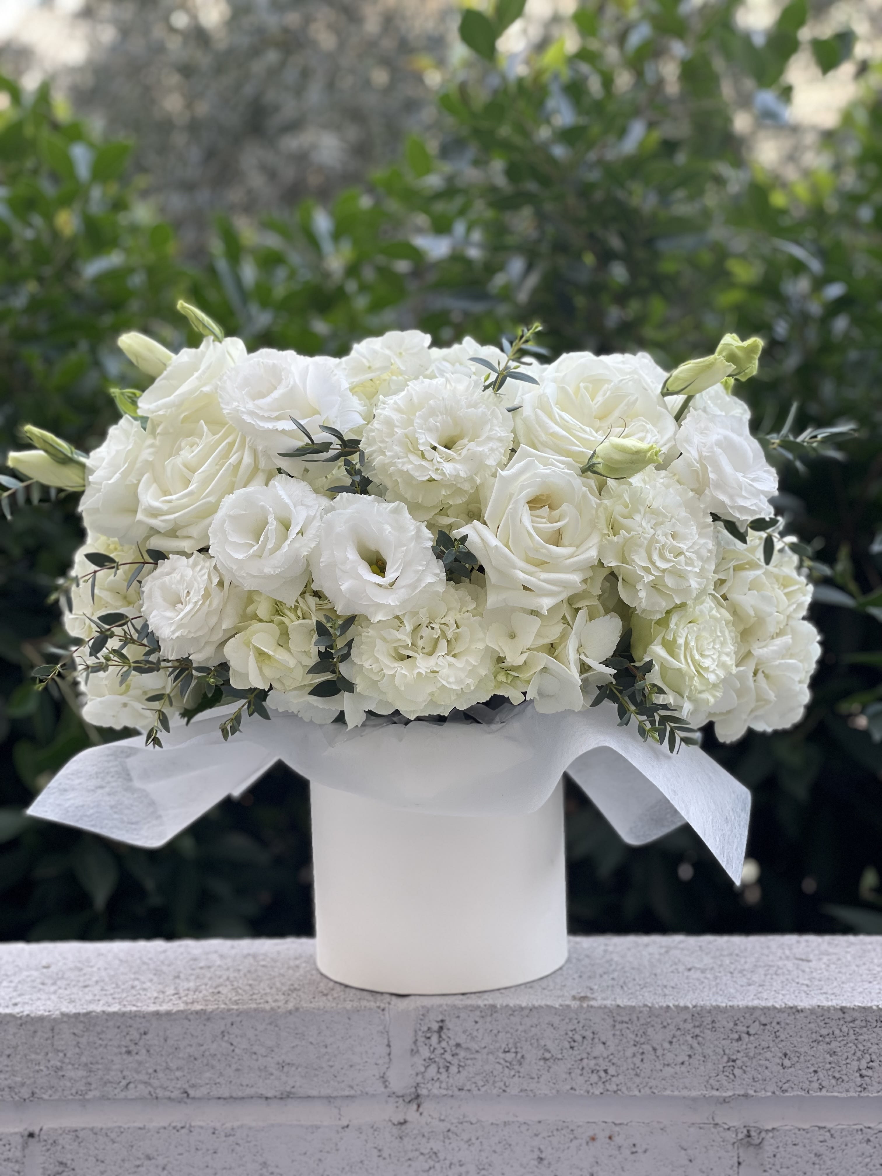 White rose and carnation bouquet in a white hatbox