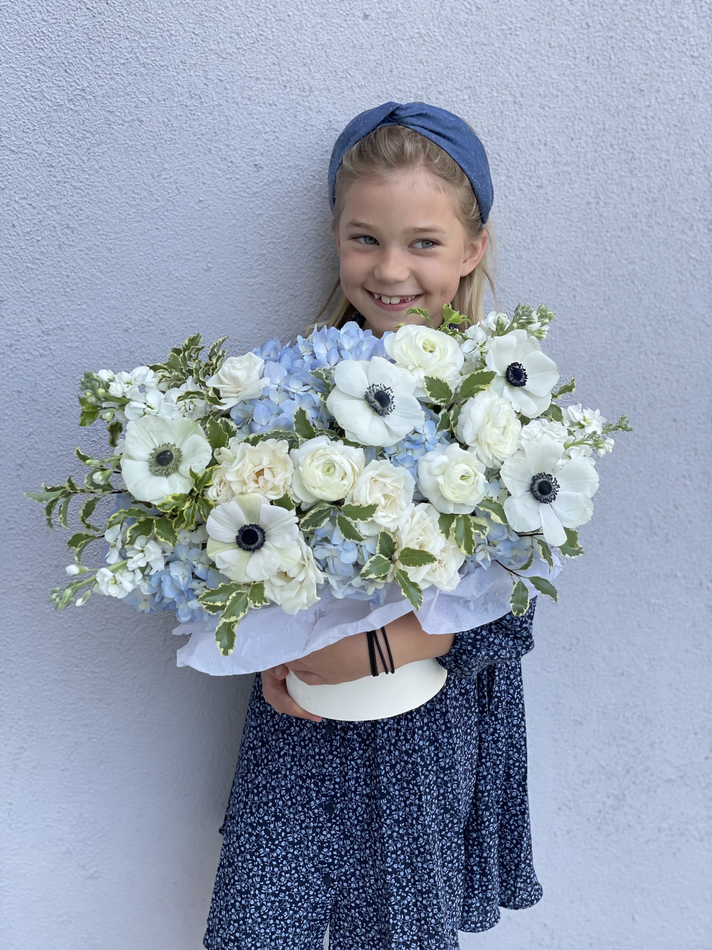 Girl holding a large bouquet of white and pale blue flowers