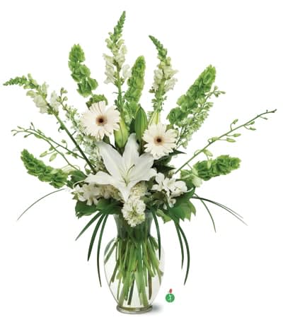 White lilies and daisies in a clear glass vase with tall green spikes