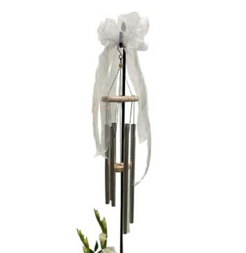 White ribbon-tied wind chime hanging on a black stand