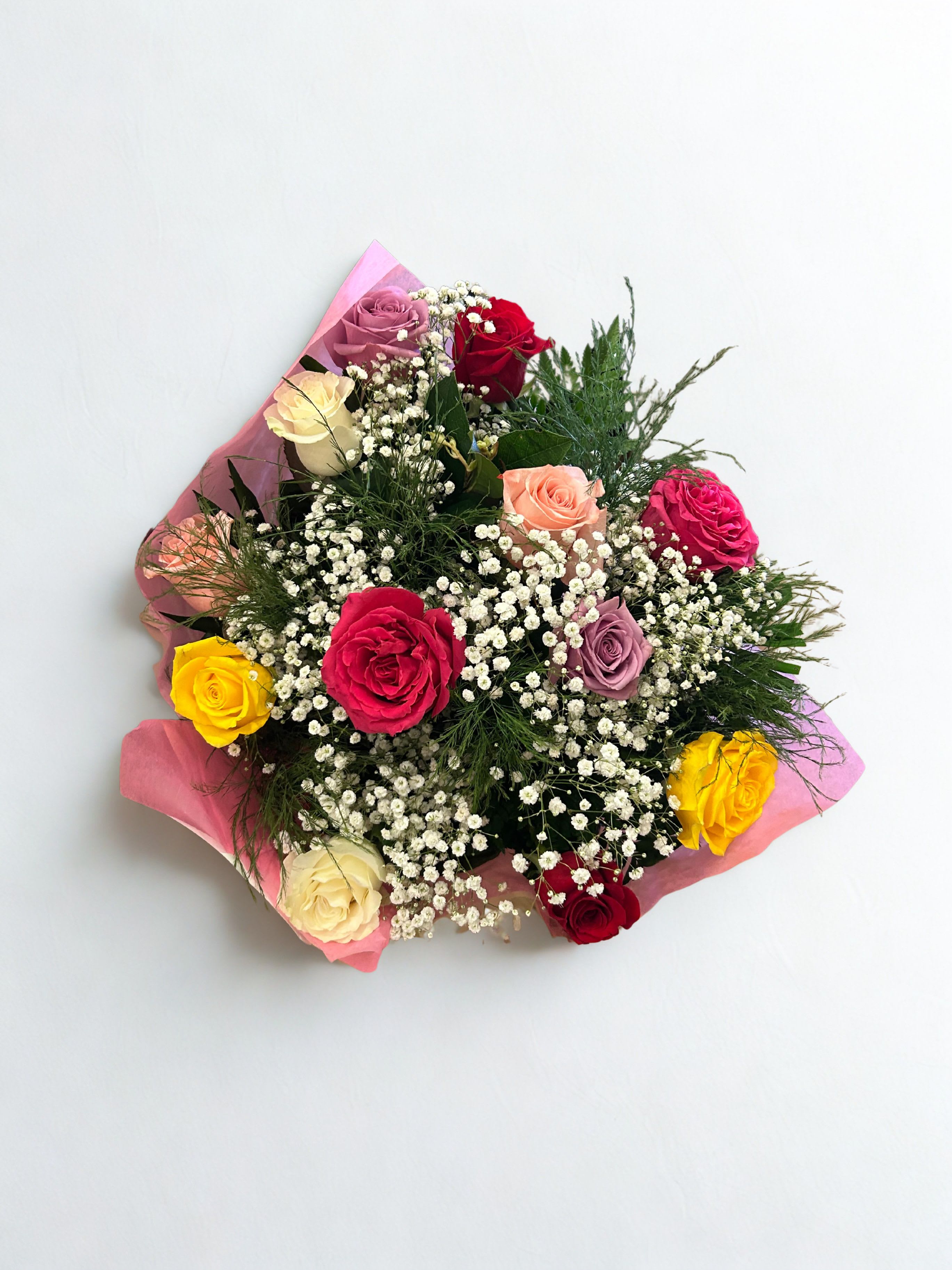 Dozen Mixed Rose Bouquet - A joyful swirl of color greets the eye: a dozen mixed rose bouquet for celebrations, thank-yous, or simply to say you're thinking of someone special.  Ideal for the person who enjoys classic roses with a lively color palette, this arrangement arrives ready to display - vase not included. Order for same-day delivery to make any ordinary day feel like a celebration.