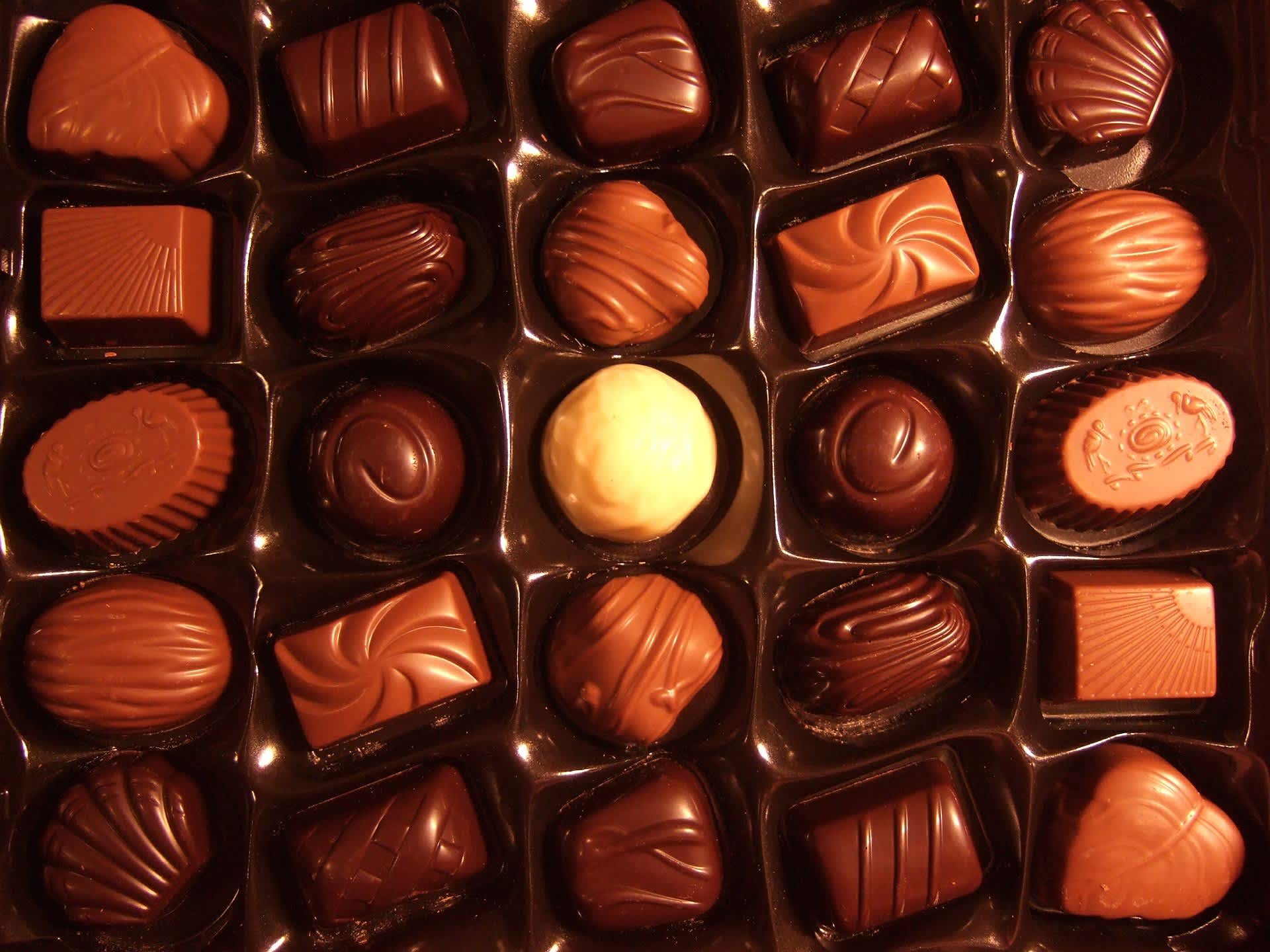 Assorted chocolates in a box with molded tops