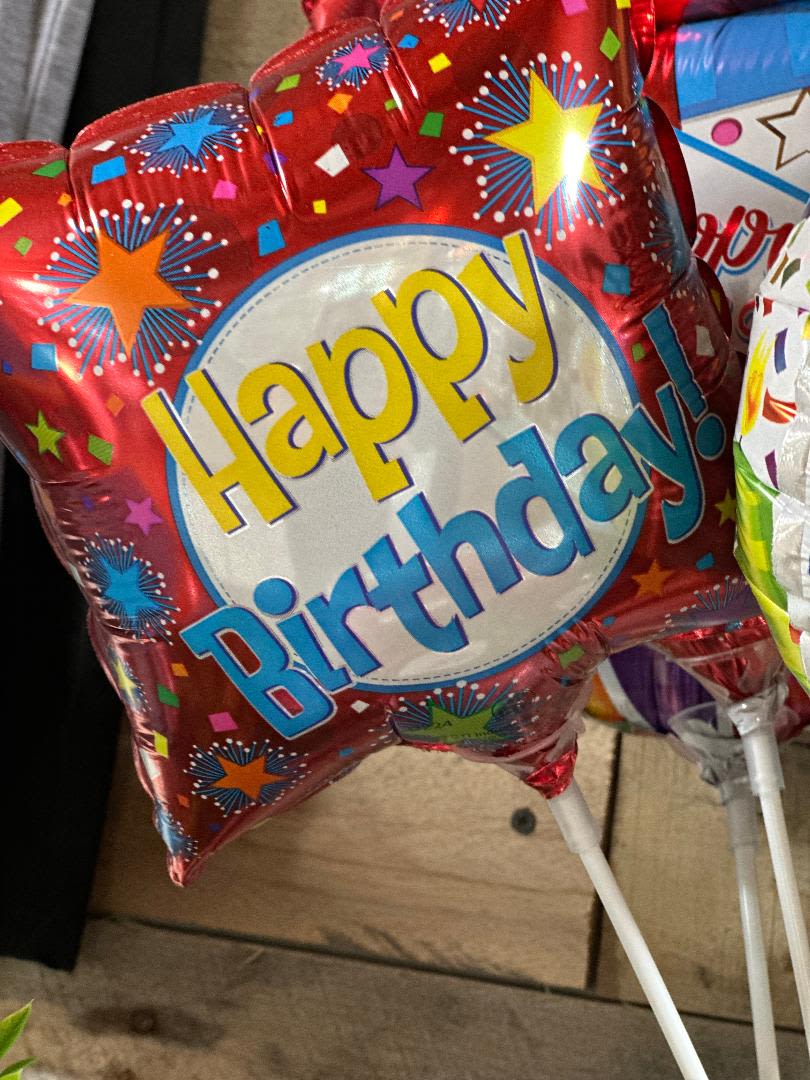 Red birthday balloon with colorful stars and "Happy Birthday" text