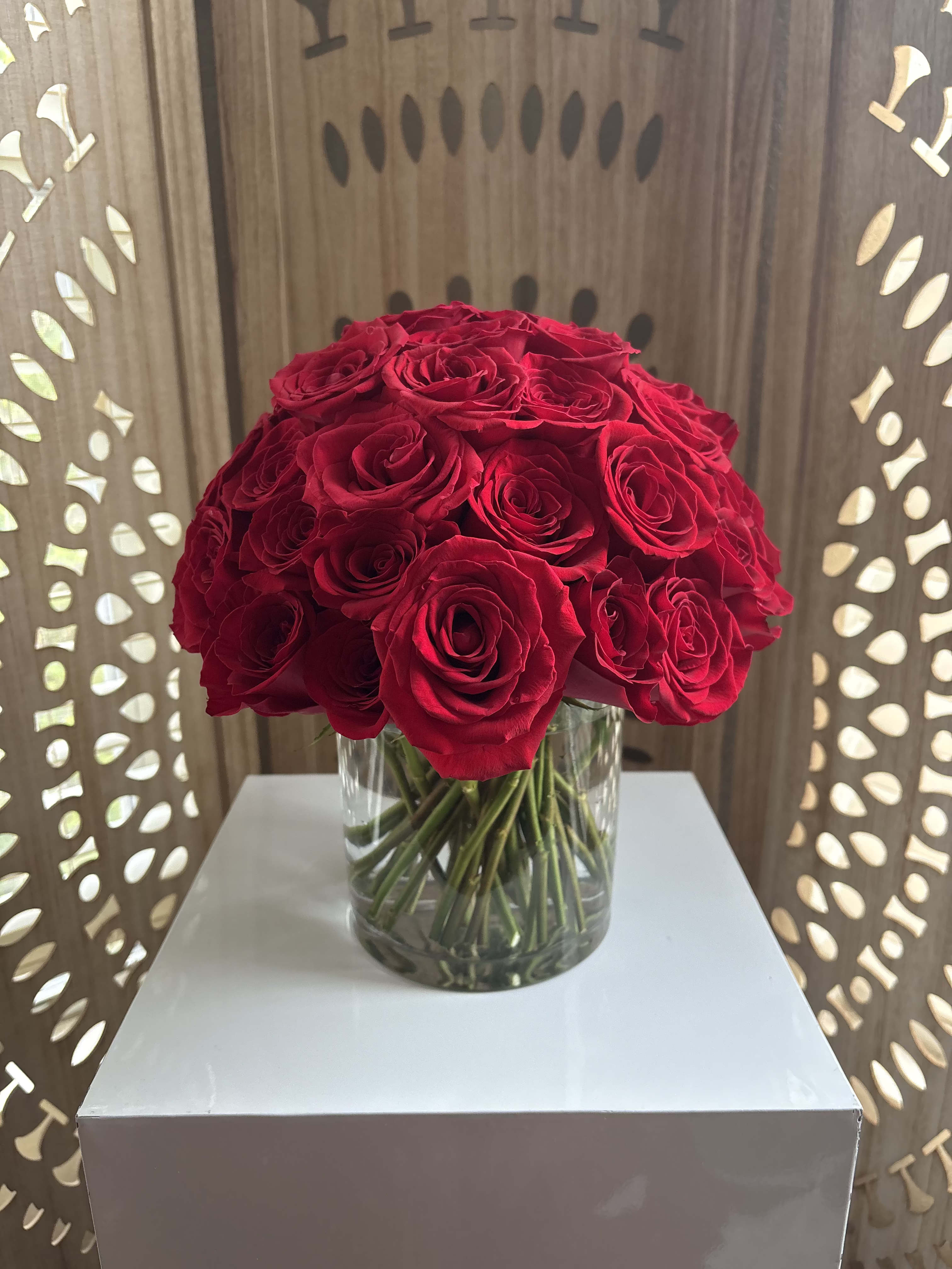 Scarlet Daydream - A lush gathering of all-red roses designed low and compact in a modern glass cylinder. Romantic, velvety, and timeless with just the right amount of drama.  