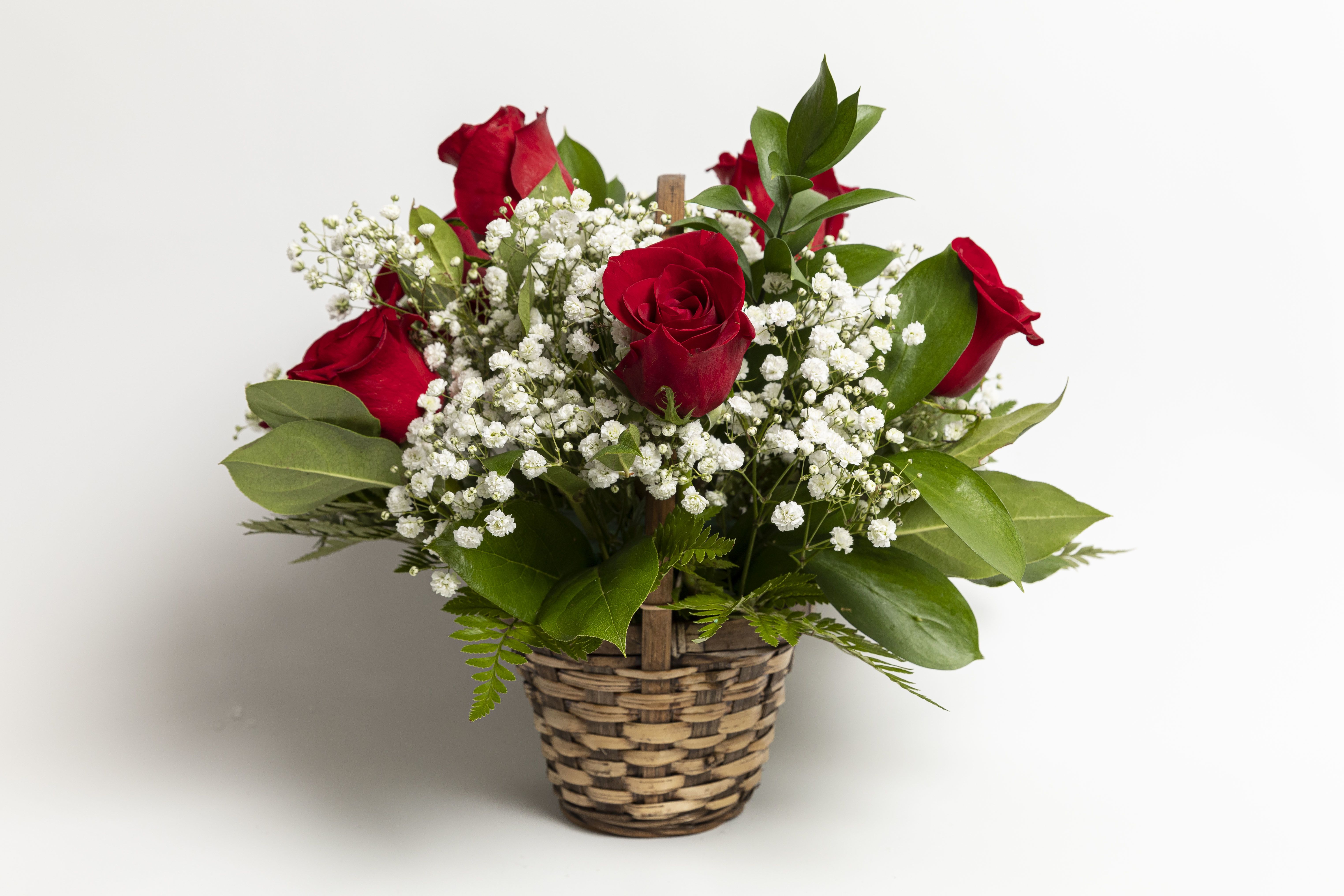 Red roses with white baby's breath in a woven basket