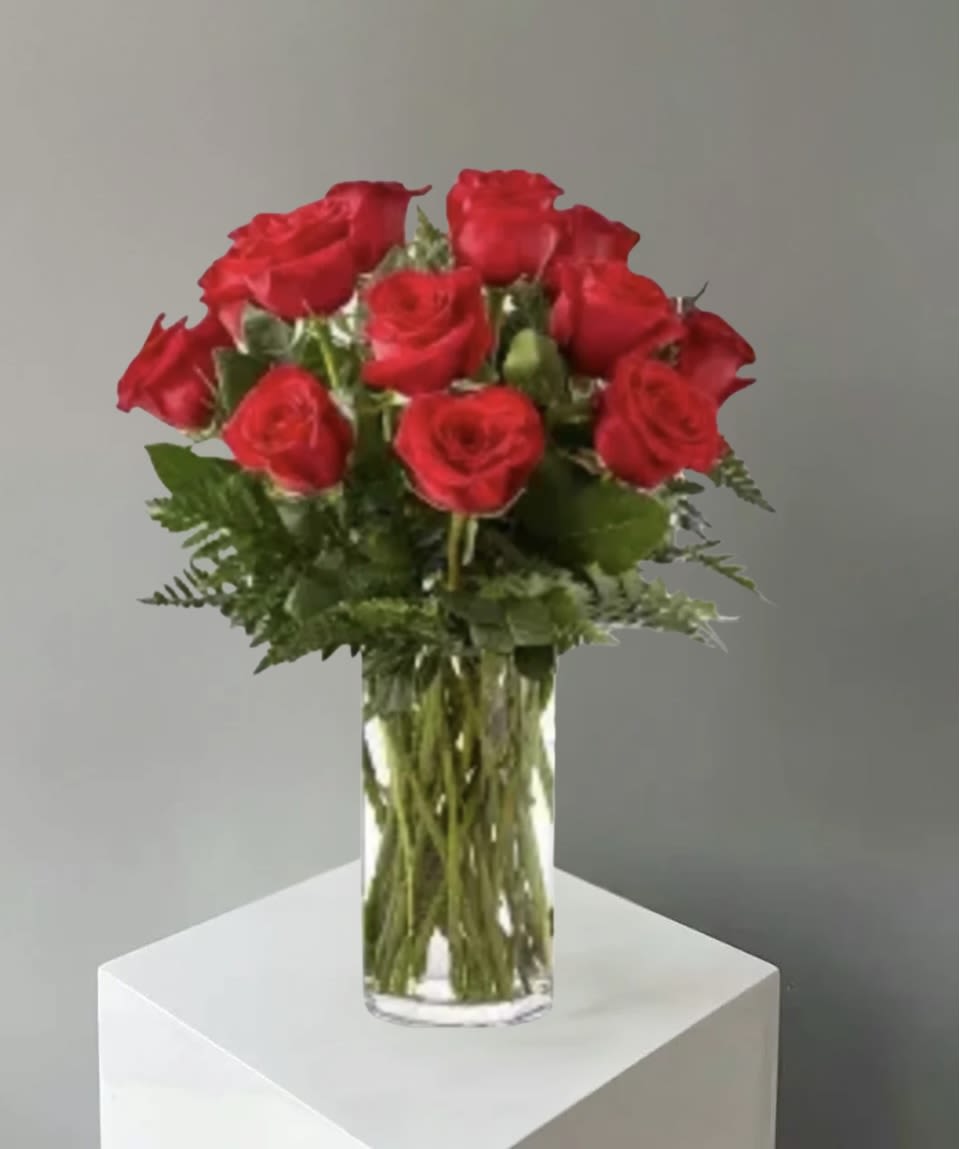 Red roses arranged in a clear glass vase