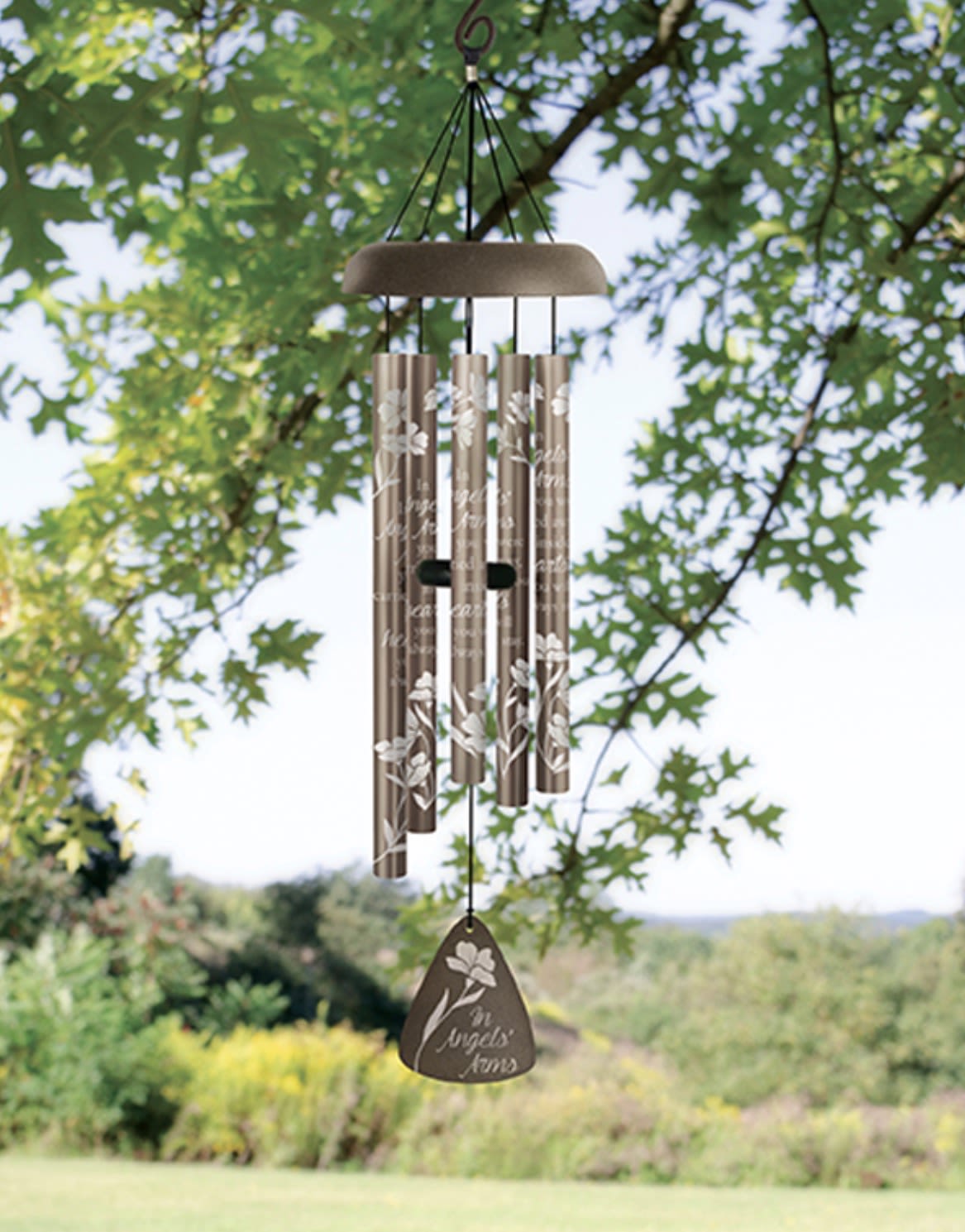 In Angels’ Arms 30” Windchime 64697 - Create a lasting impression with decorative aluminum wind chimes designed for far more than sympathy alone. These keepsake chimes make thoughtful gifts for birthdays, celebrations of life, encouragement, anniversaries, churches, gardens, holidays, thank-you gifts, memorials, and meaningful everyday moments. Each design features artwork and sentiment permanently applied to the aluminum tubes for a beautiful, lasting finish that catches both light and sound.  Available in multiple presentation options to fit the occasion. The Standard option includes the wind chime boxed for gifting or beautifully displayed with ribbon accents. The Deluxe option includes display on a temporary leased stand for churches, visitation services, receptions, offices, events, and special gatherings. The Premium option adds a fresh flower spray across the top for a striking presentation piece that blends keepsake gifting with elegant floral styling.  Perfect for homes, patios, porches, gardens, churches, funeral services, celebration events, or anyone who finds comfort in peaceful sound and meaningful décor. These wind chimes are designed to be displayed, gifted, remembered, and enjoyed long after the moment has passed.