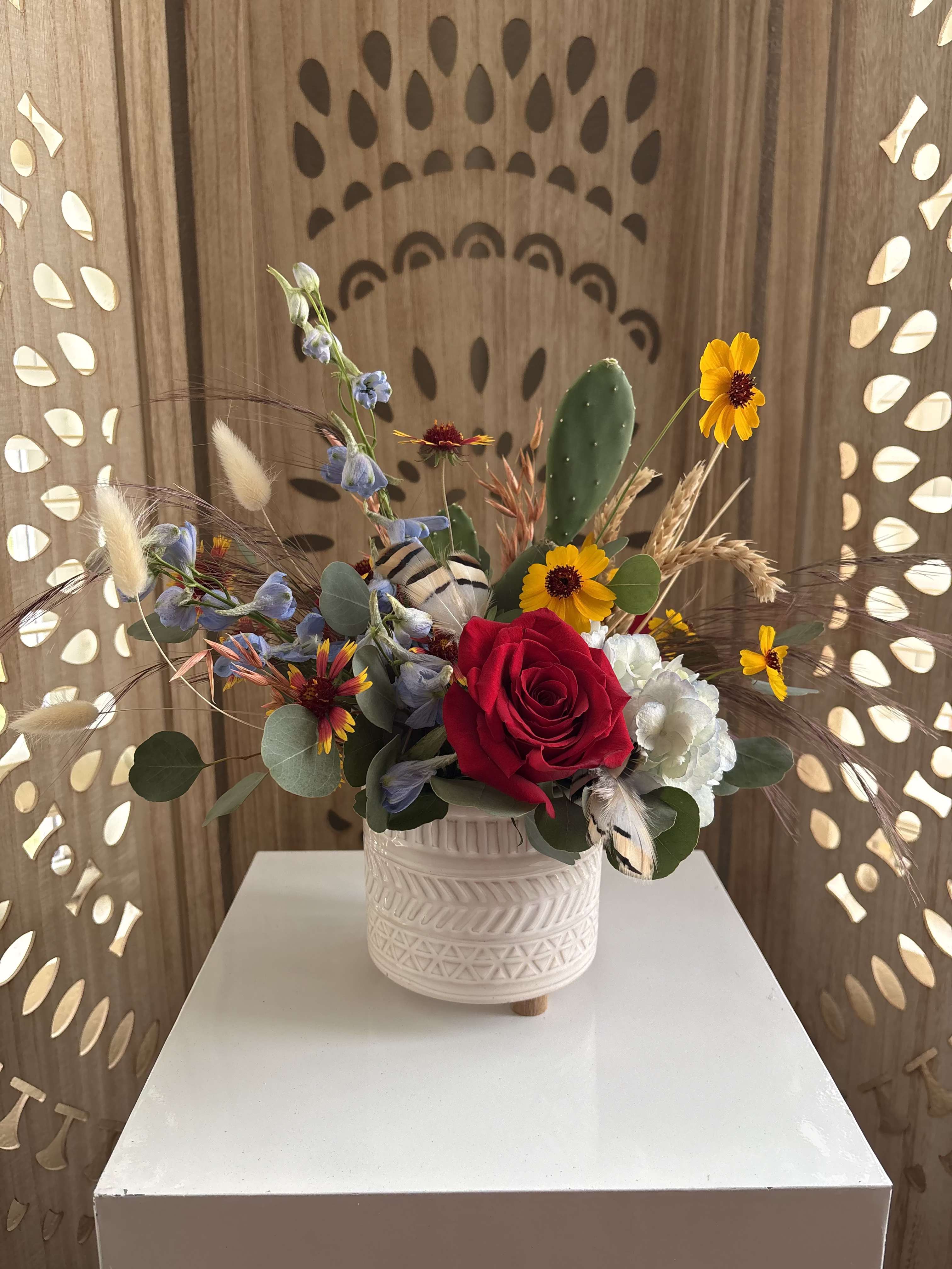 Desert Dreamcatcher - This rustic wildflower arrangement features vibrant red, yellow, and blue blooms, natural feathers, and a petite cactus tucked inside for a lasting touch once the flowers have faded. Small ode to my aunt who instilled the Native American Spirit in me. 