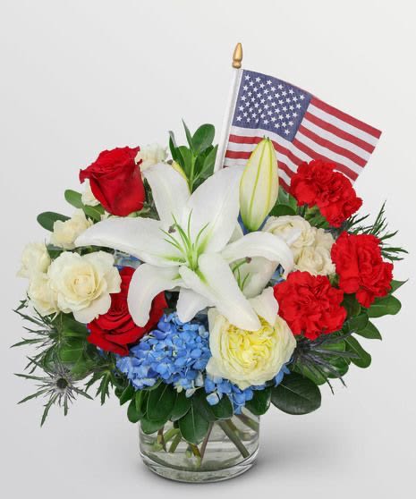     Proud to Be American Bouquet -     This heartfelt arrangement showcases classic red, white, and blue blooms accented with an American flag to celebrate freedom, bravery, and the spirit of our nation. A thoughtful gift for patriotic holidays and military families.