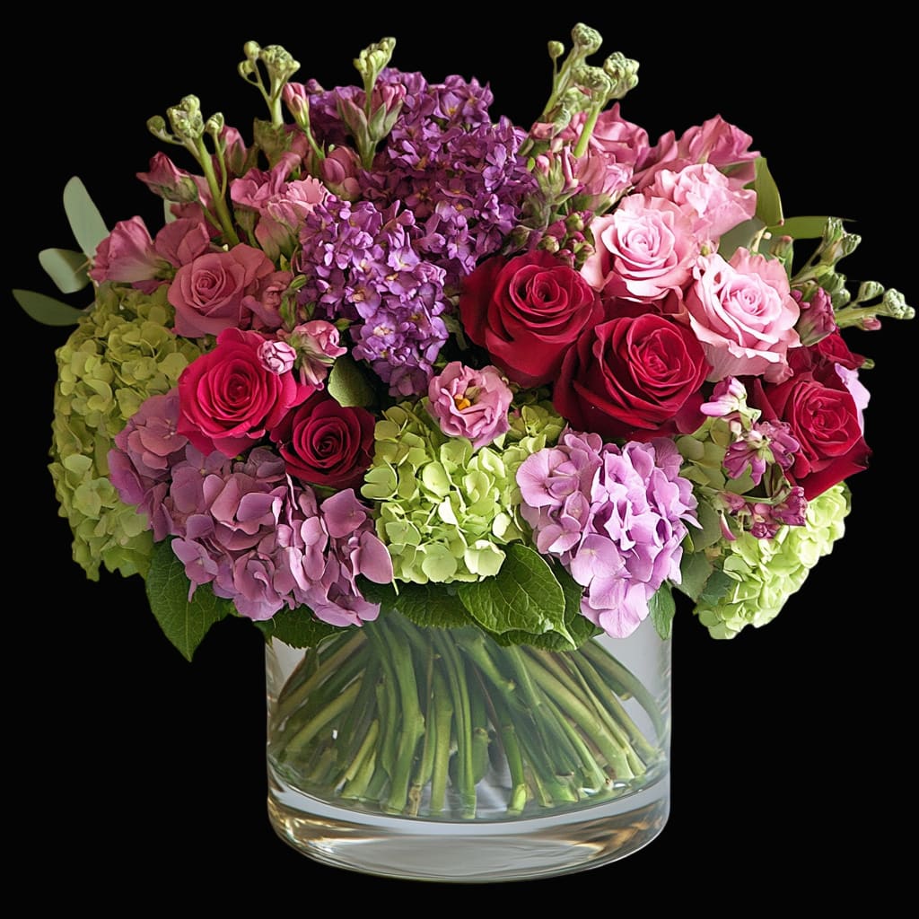 Bouquet of pink and red roses with purple hydrangeas in a glass vase