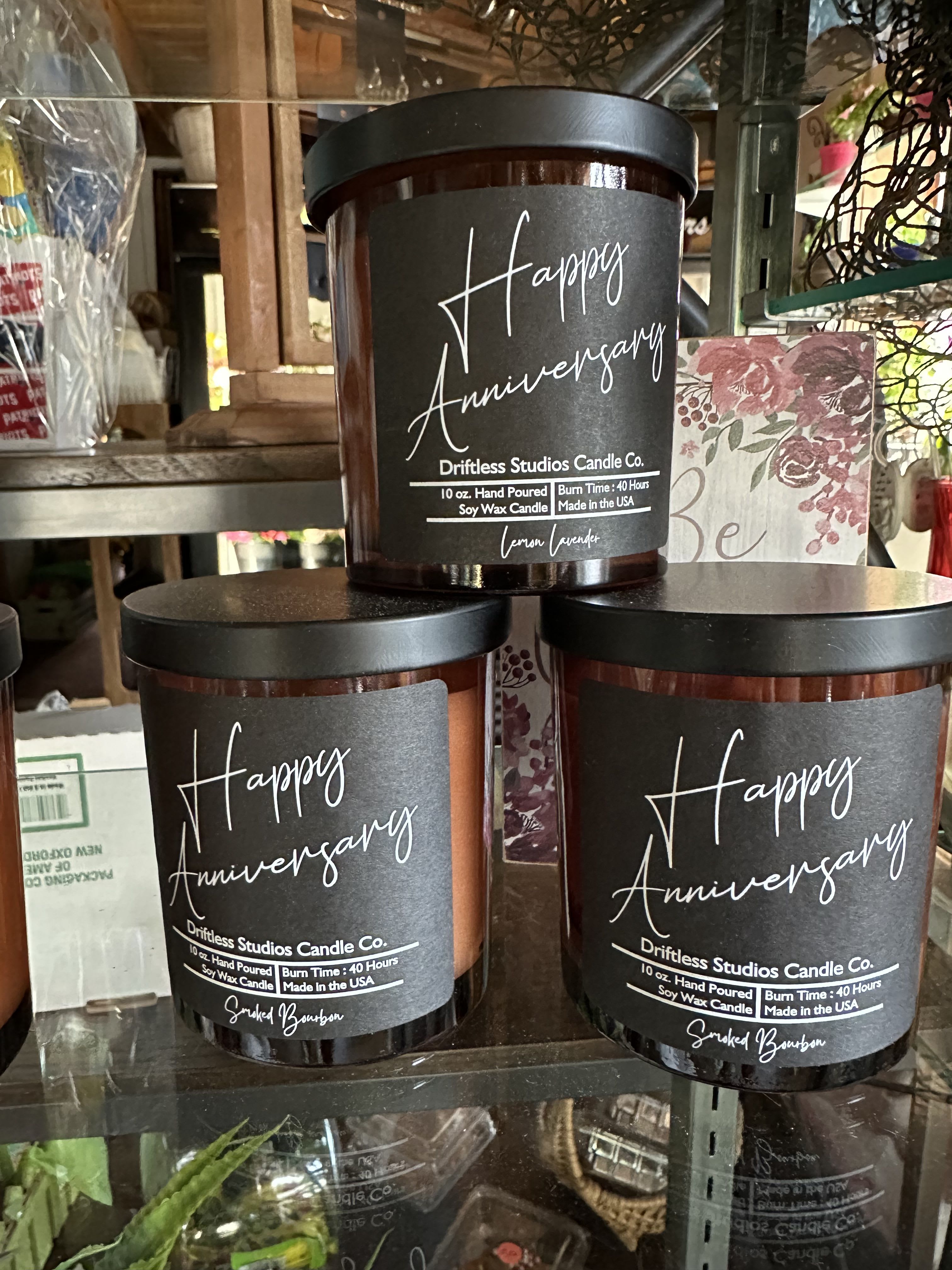 Three anniversary candles in dark glass jars with black lids