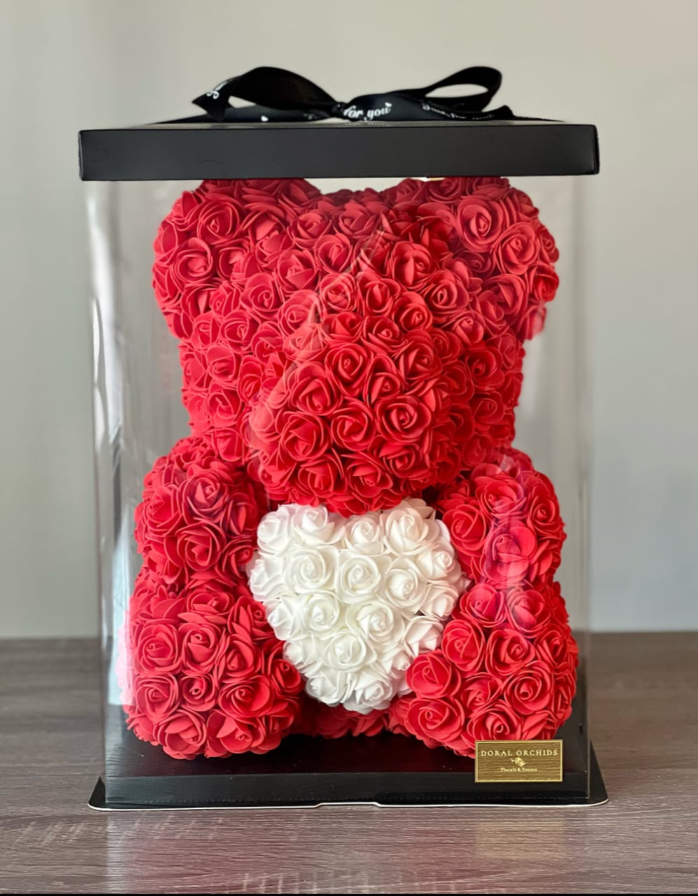Red rose teddy bear in a clear gift box with a white heart