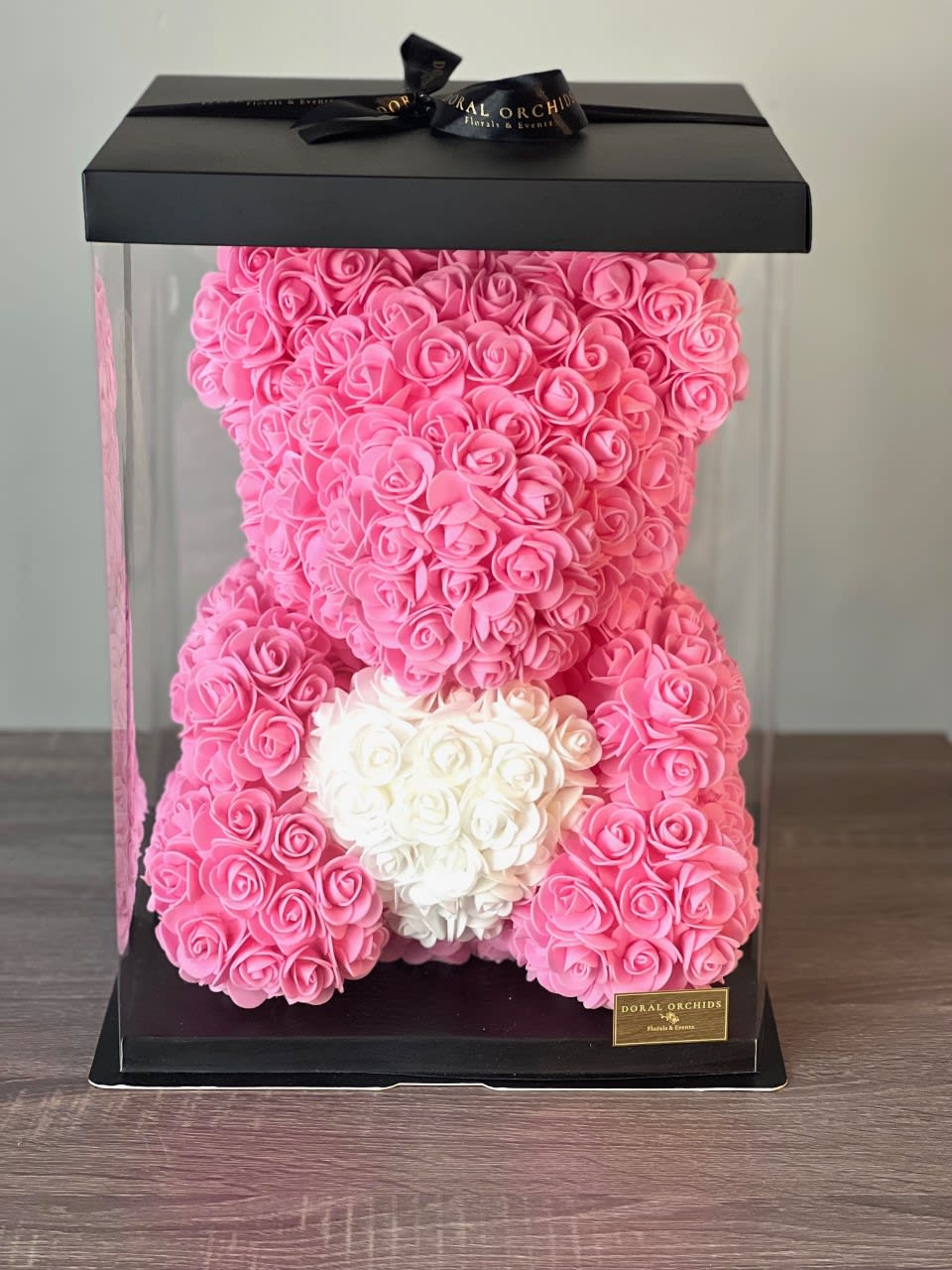 Pink and white rose teddy bear in a clear gift box with a black lid