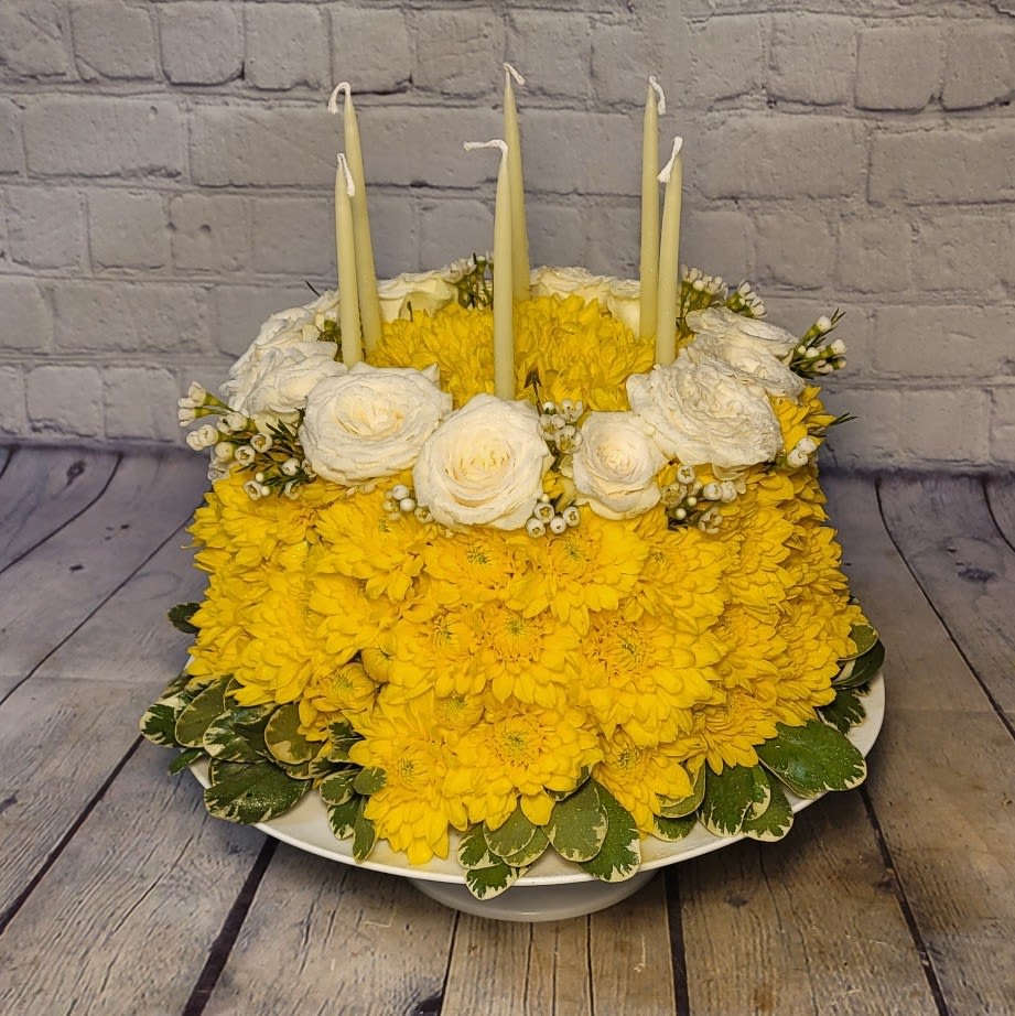 Make A Wish - Make A Wish is a fresh and creative twist on the classic birthday cake. This one-of-a-kind design is handcrafted in the shape of a cake using floral foam and fully covered in fresh, seasonal flowers. While the pictured design features cheerful yellow and white blooms, each floral cake can be customized in the birthday person’s favorite color palette using naturally occurring flower colors. Perfect for birthdays of all ages, this floral cake makes a joyful centerpiece and a memorable alternative to traditional flowers —candles included!  Flower types and exact shades may vary based on seasonal availability. Custom color requests are welcome; please note that flowers are limited to natural floral colors.