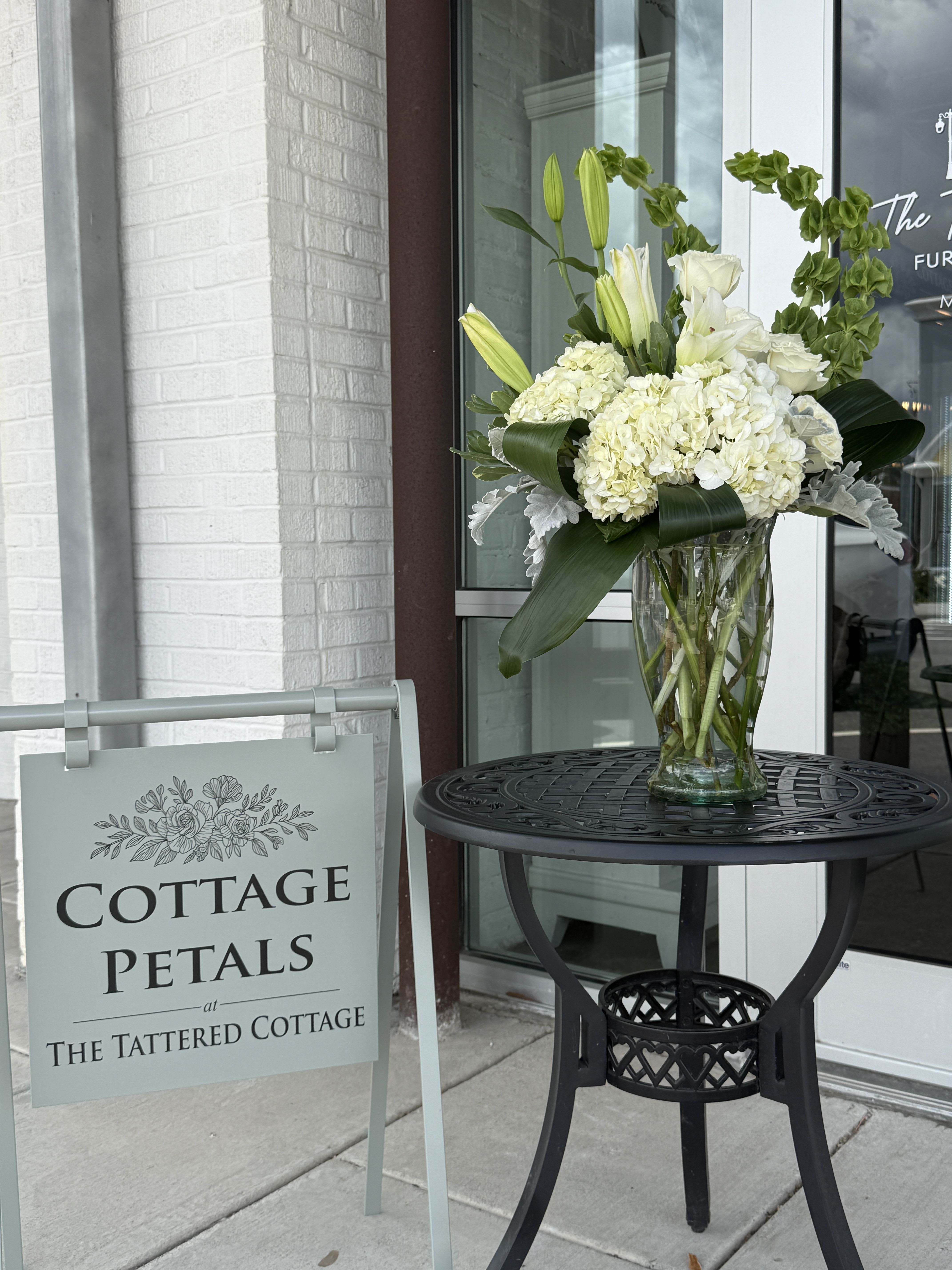 Ivory Garden Elegance - Classic, graceful, and effortlessly elegant, the Ivory Garden Elegance arrangement features lush white hydrangeas, fragrant white lilies, premium white roses, and fresh greenery gathered beautifully in a clear glass vase. Its soft neutral palette creates a timeless design perfect for sympathy, celebrations, anniversaries, or sending a thoughtful gesture of peace and comfort.  Designed with height, texture, and natural movement, this arrangement brings a sophisticated garden-inspired feel to any home, office, or service.  Flower varieties may vary slightly based on seasonal availability, but the overall style, color palette, and fullness of the arrangement will always be maintained.