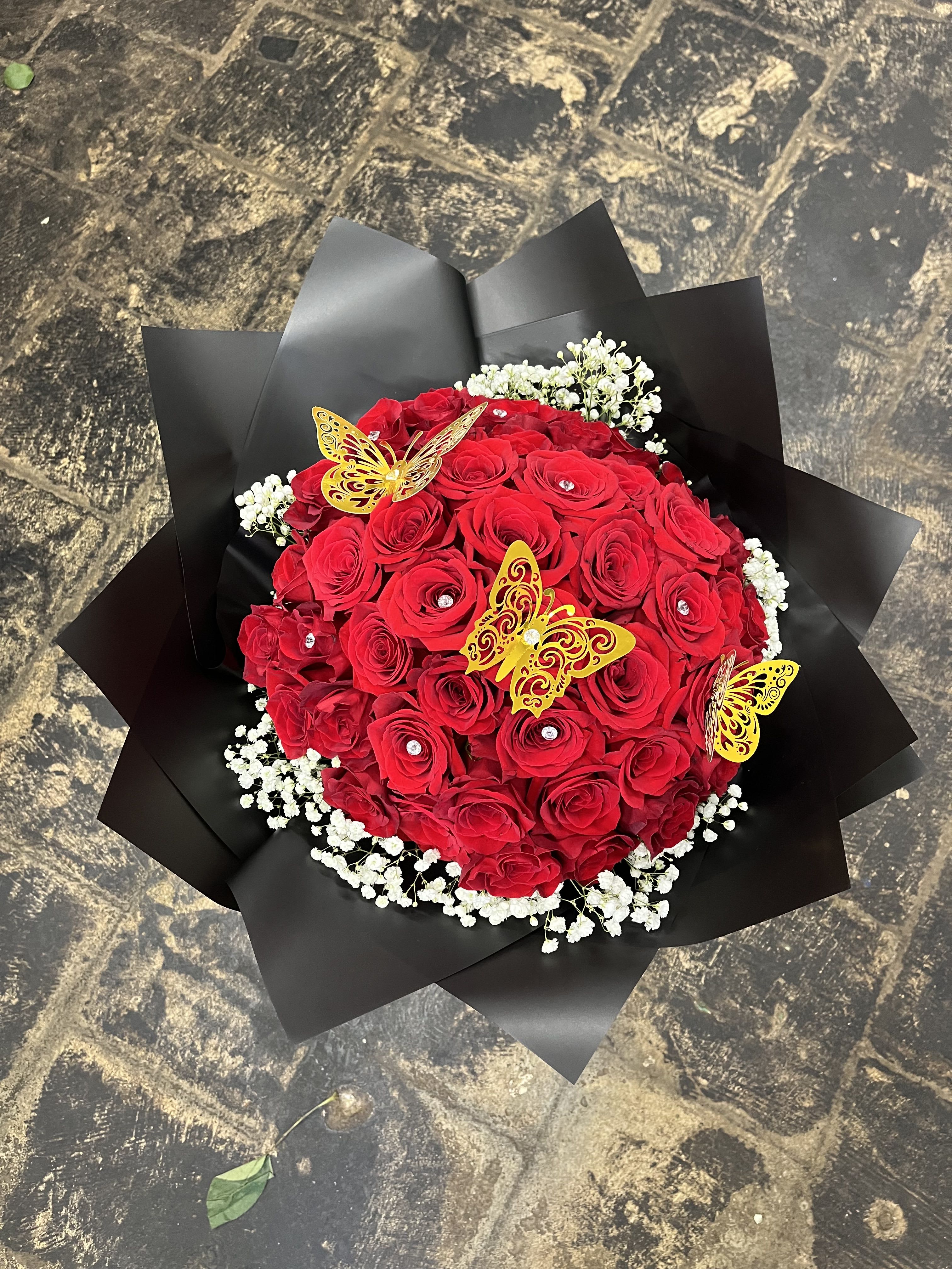 Red rose bouquet with white baby's breath and yellow butterfly decorations