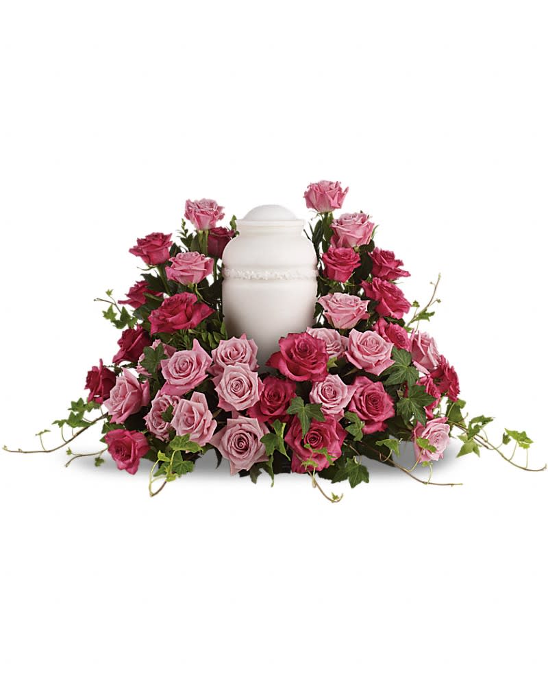 Pink and magenta roses arranged around a white urn