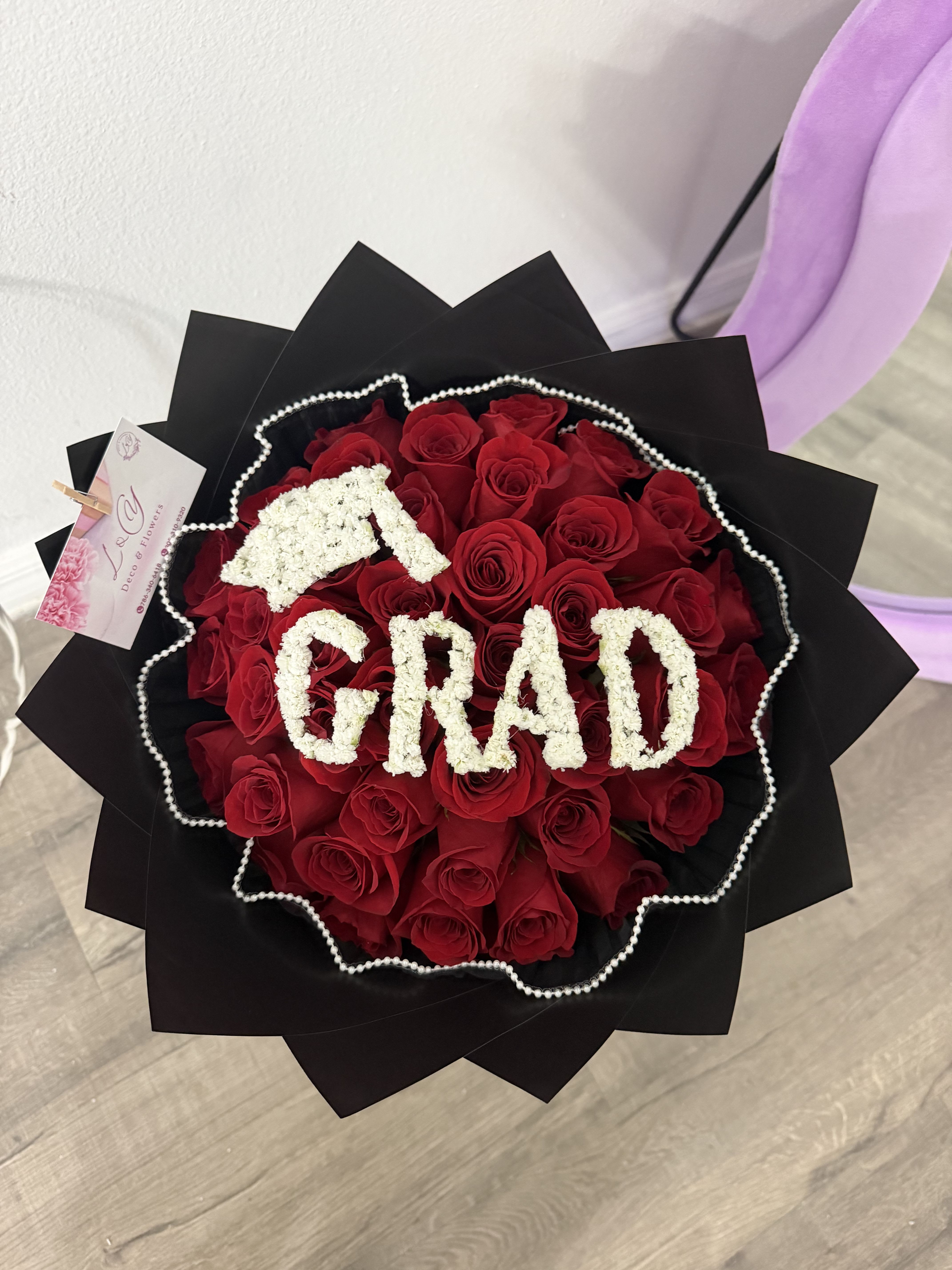 Graduation Bouquet - Elegante ramo de graduación diseñado con rosas rojas premium y detalles florales blancos formando la palabra GRAD. Perfecto para sorprender en graduaciones.
