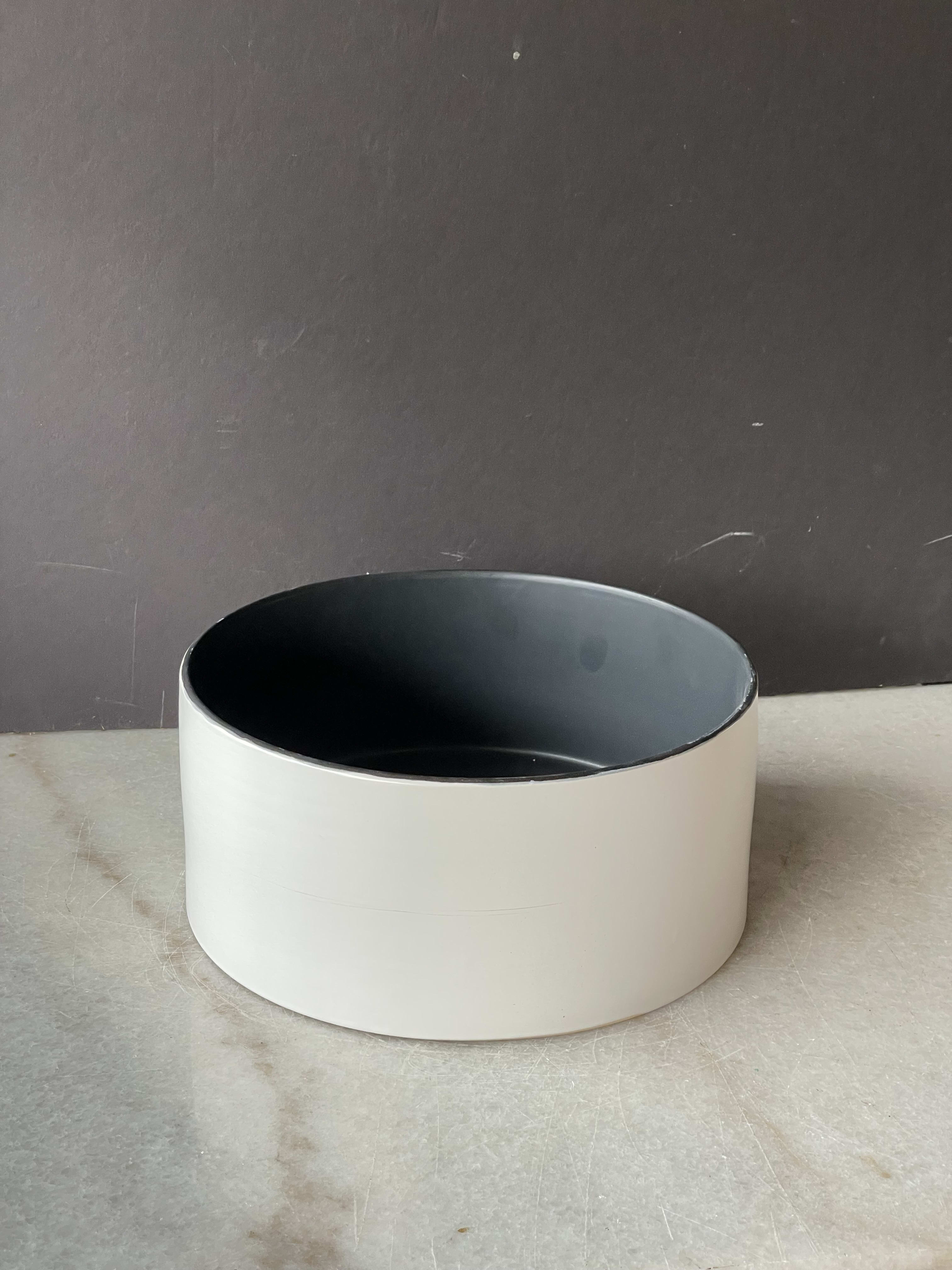 Empty round white planter with a dark interior