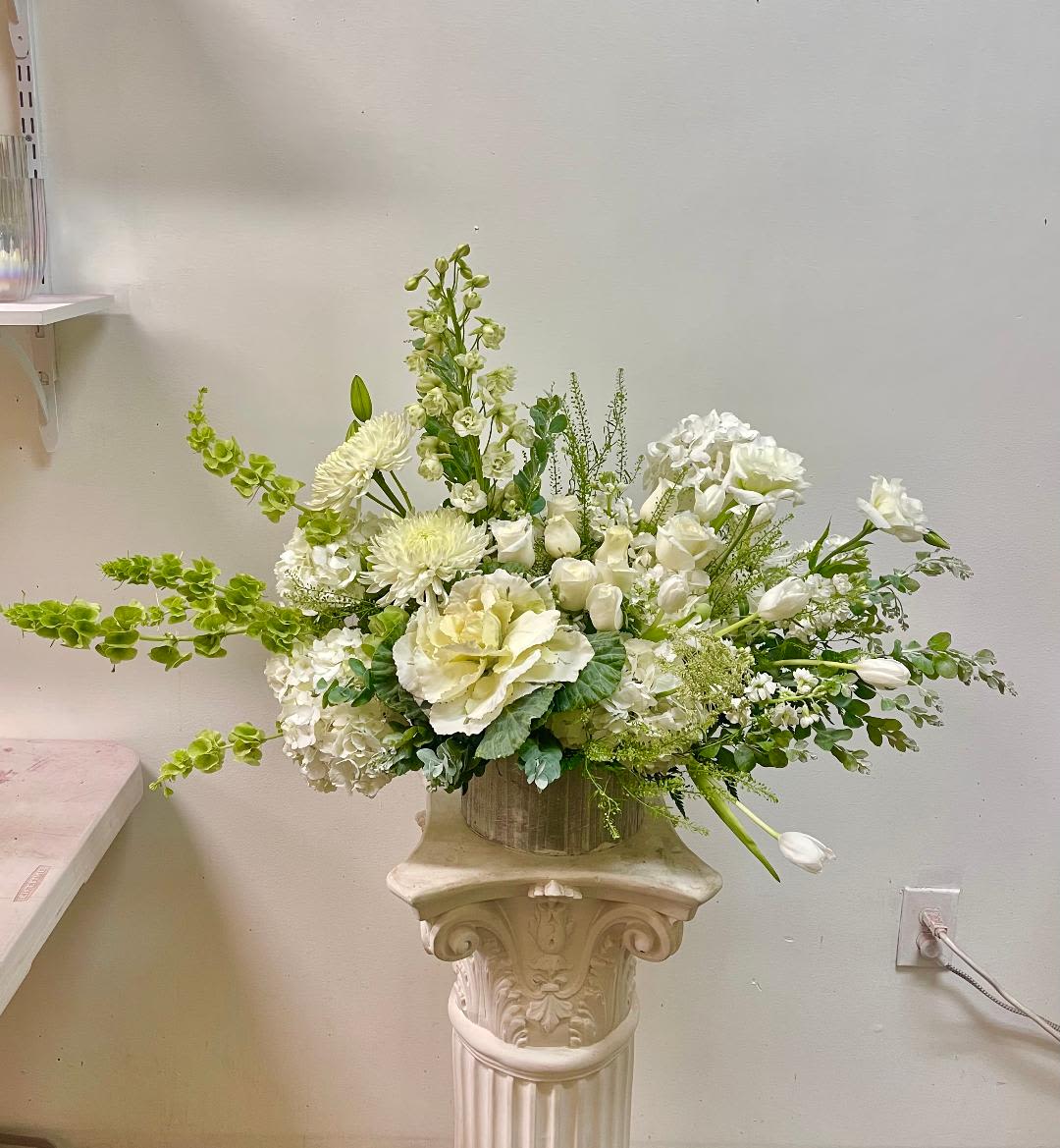 Garden Verdes - Theme Colors: Shades of White, and Green  Featured Blooms: Roses, Tulips, Cabbage, Delphinium, Hydrangea, Lisianthus, Chrysanthemum, in the wood box  HK Flowers have a uniqueness of florals and seasonal blooms, certain flowers or colors may not be available as each season affects the availability, color, size, and shape of each floral bloom. Some flowers may be substituted accordingly.  Photos are used as a reference for the color palette and is NOT indicated of the final product. 