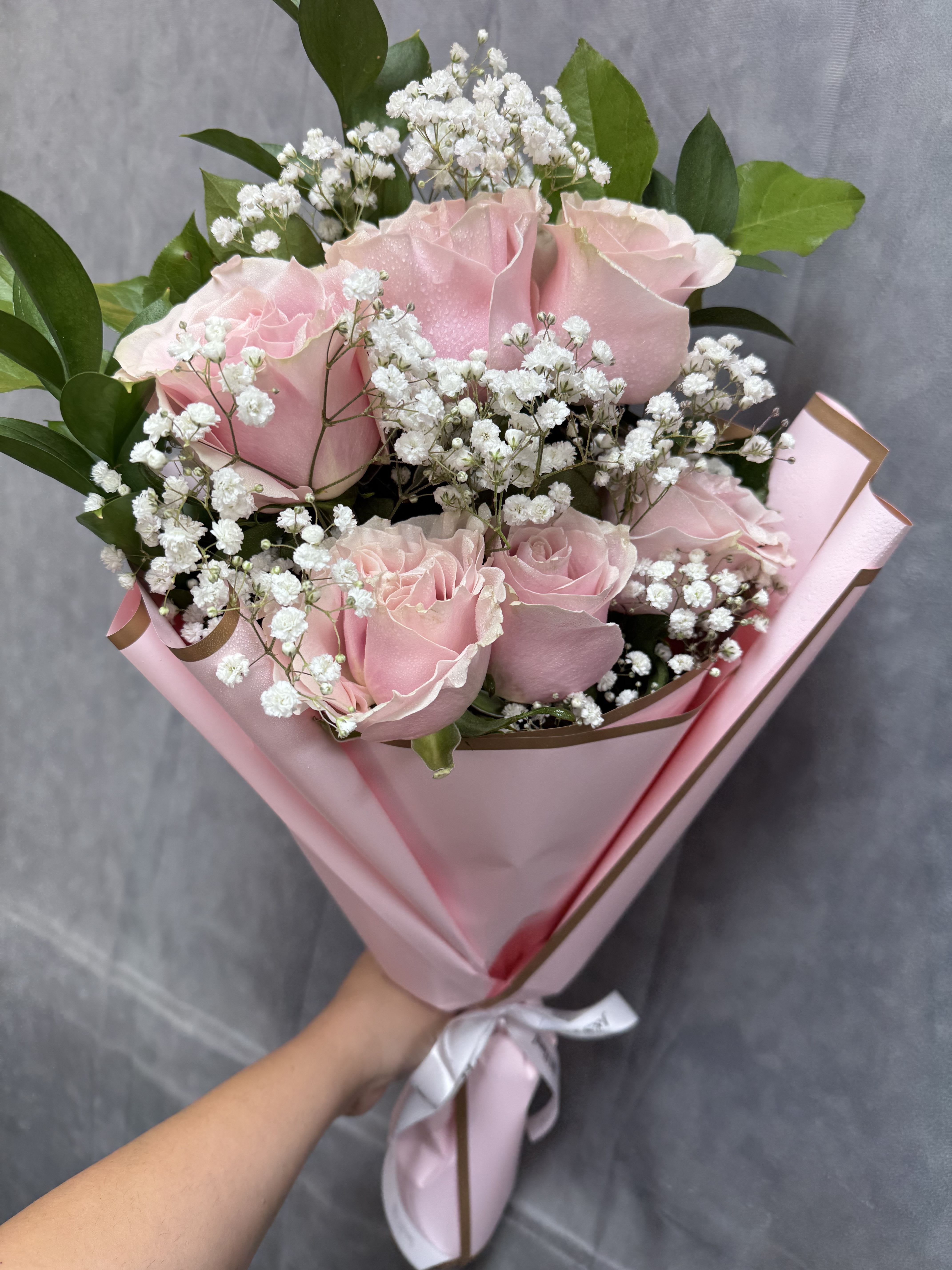 Pink roses with white baby's breath in pink wrapping