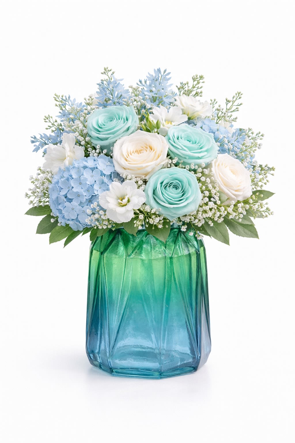 Seafoam Serenity - A refreshing coastal-inspired design that brings calm, elegance, and soft ocean tones into any space. This arrangement features beautiful seafoam-tinted roses paired with classic white roses, soft blue hydrangeas, and delicate seasonal accents. Designed in a textured teal glass vase, it creates a soothing, beachy aesthetic—perfect for birthdays, sympathy, thank you gifts, or everyday luxury. Flower colors and varieties may vary slightly based on availability while maintaining the same look and feel.