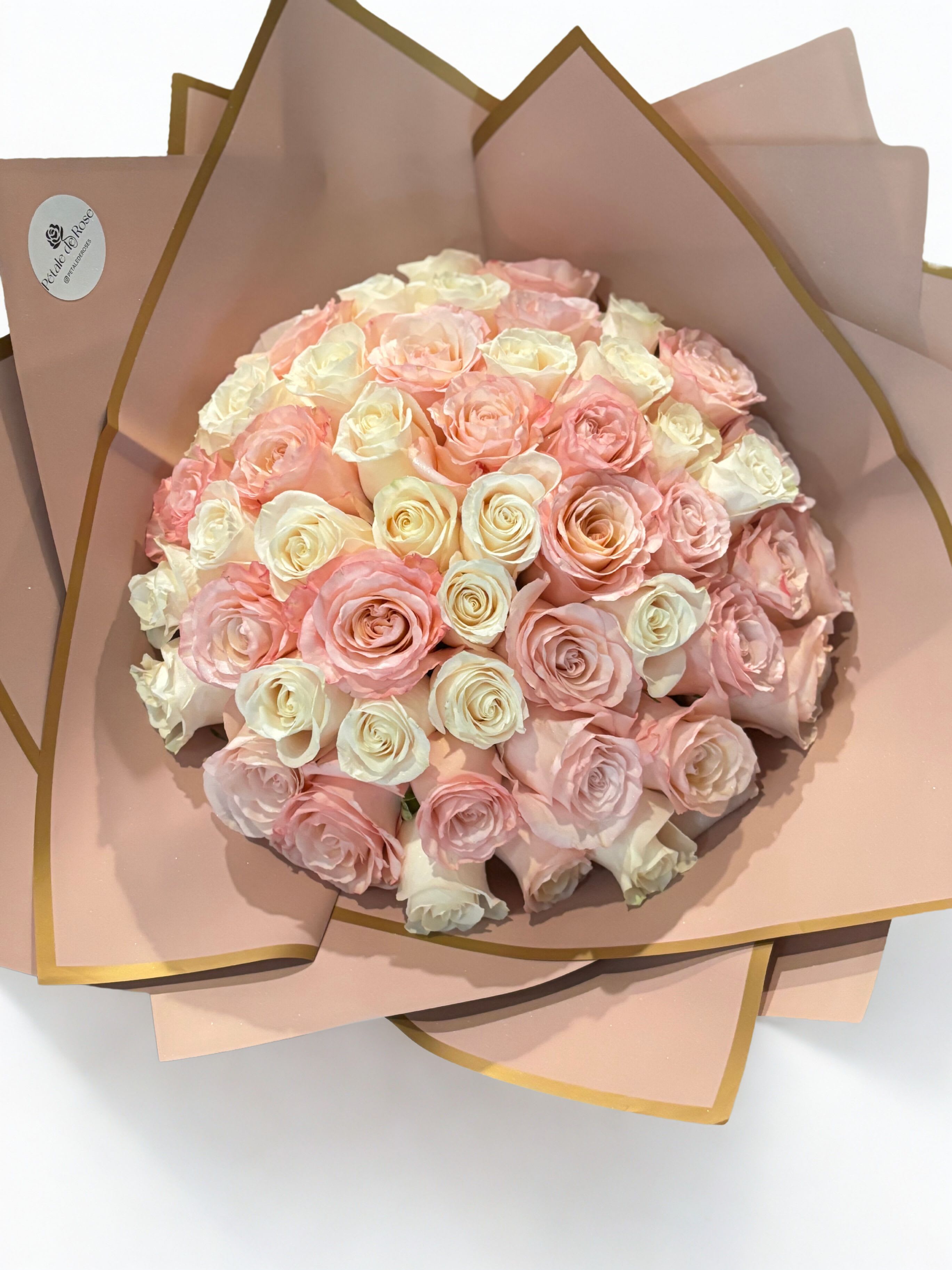 Sugar Rosé Bouquet - A stunning bouquet of 48 premium roses in soft pink and ivory tones, designed to create a timeless and elegant statement. Each arrangement is handcrafted with care, blending romantic hues that may slightly vary depending on seasonal availability.  Perfect for anniversaries, birthdays, or any moment that deserves something truly special    Details: • 48 premium roses • Pink &amp; white tones (color may vary slightly) • Elegant wrapping style • Handcrafted designThis 