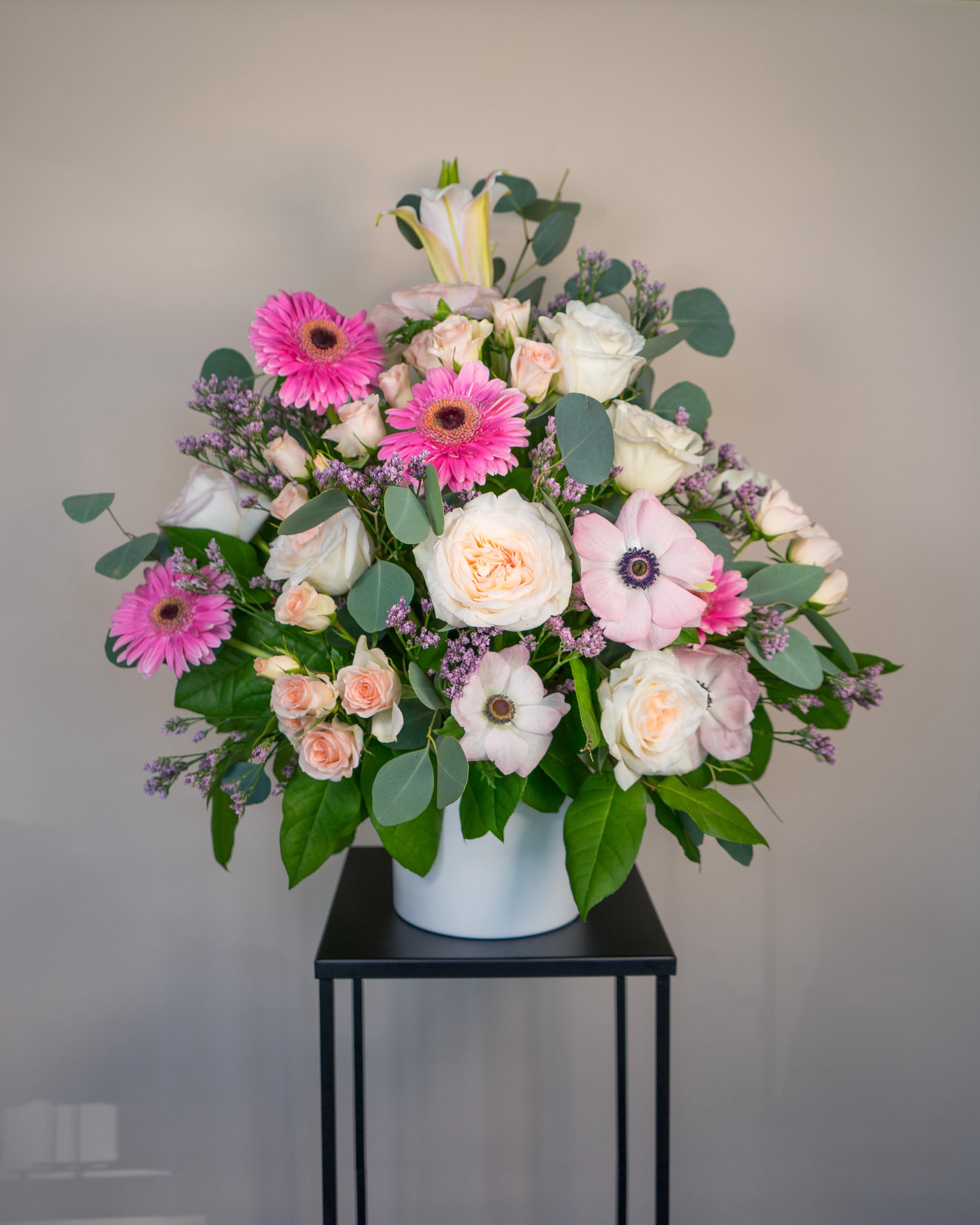 Pink and white mixed flower arrangement in a white vase