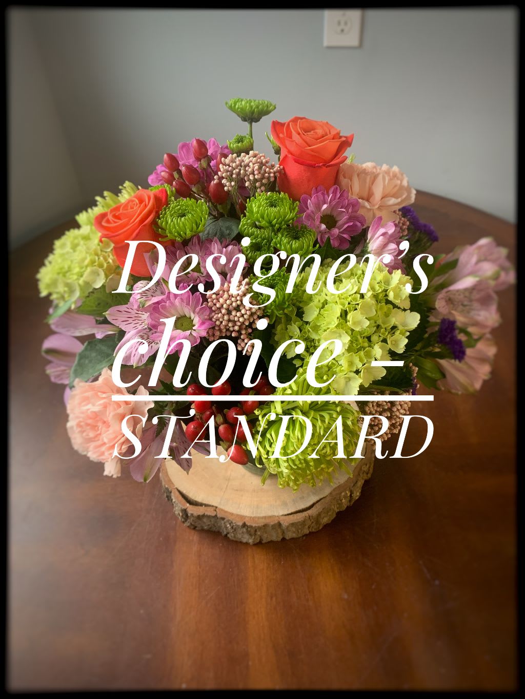 Mixed bouquet with roses, chrysanthemums, and hydrangeas on a wood slice base