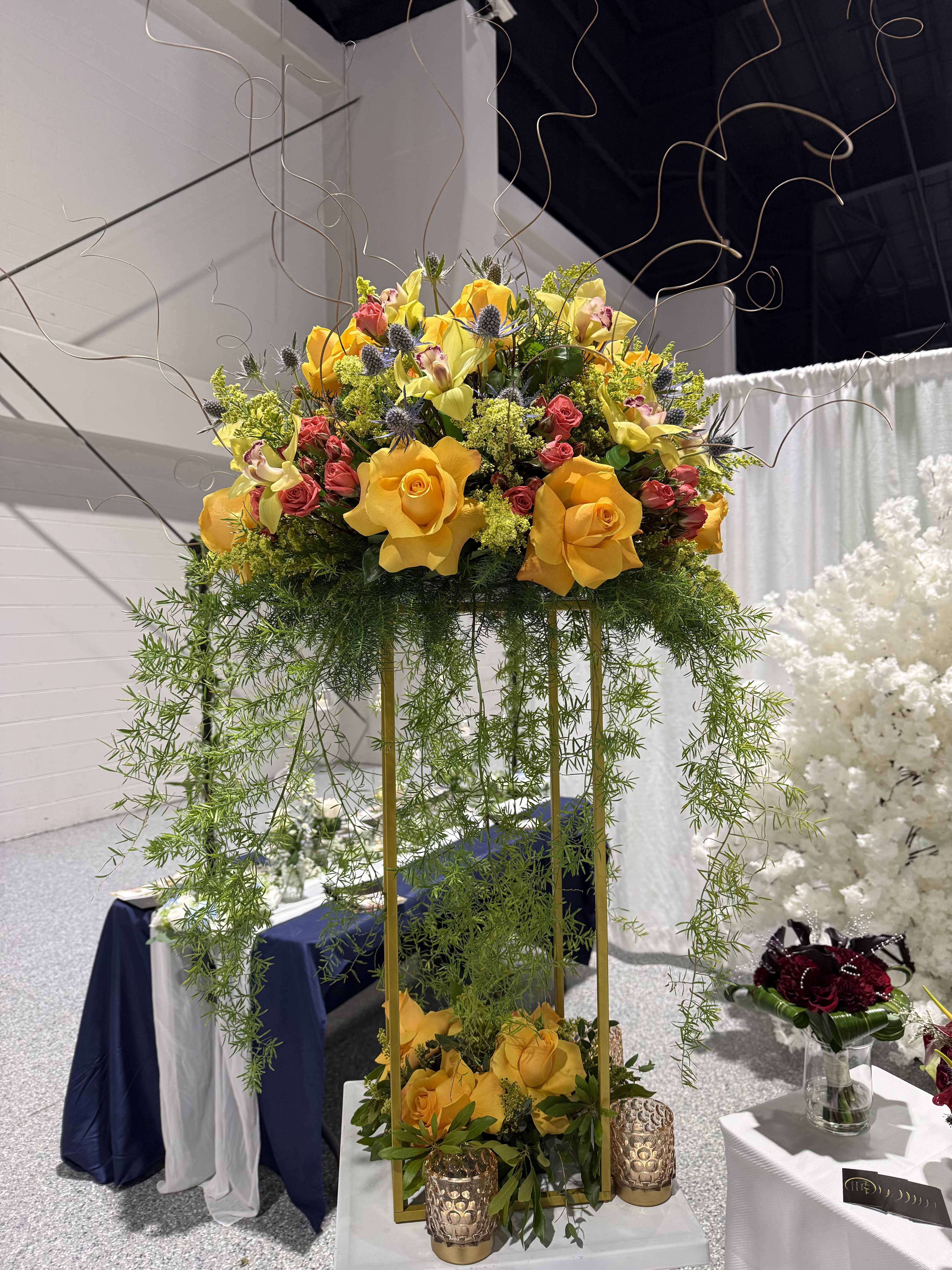 Classic High Floral Centerpiece - A breathtaking high centerpiece designed with beautiful florals to create a romantic and sophisticated atmosphere. Ideal for adding height, elegance, and a dramatic touch to your event décor