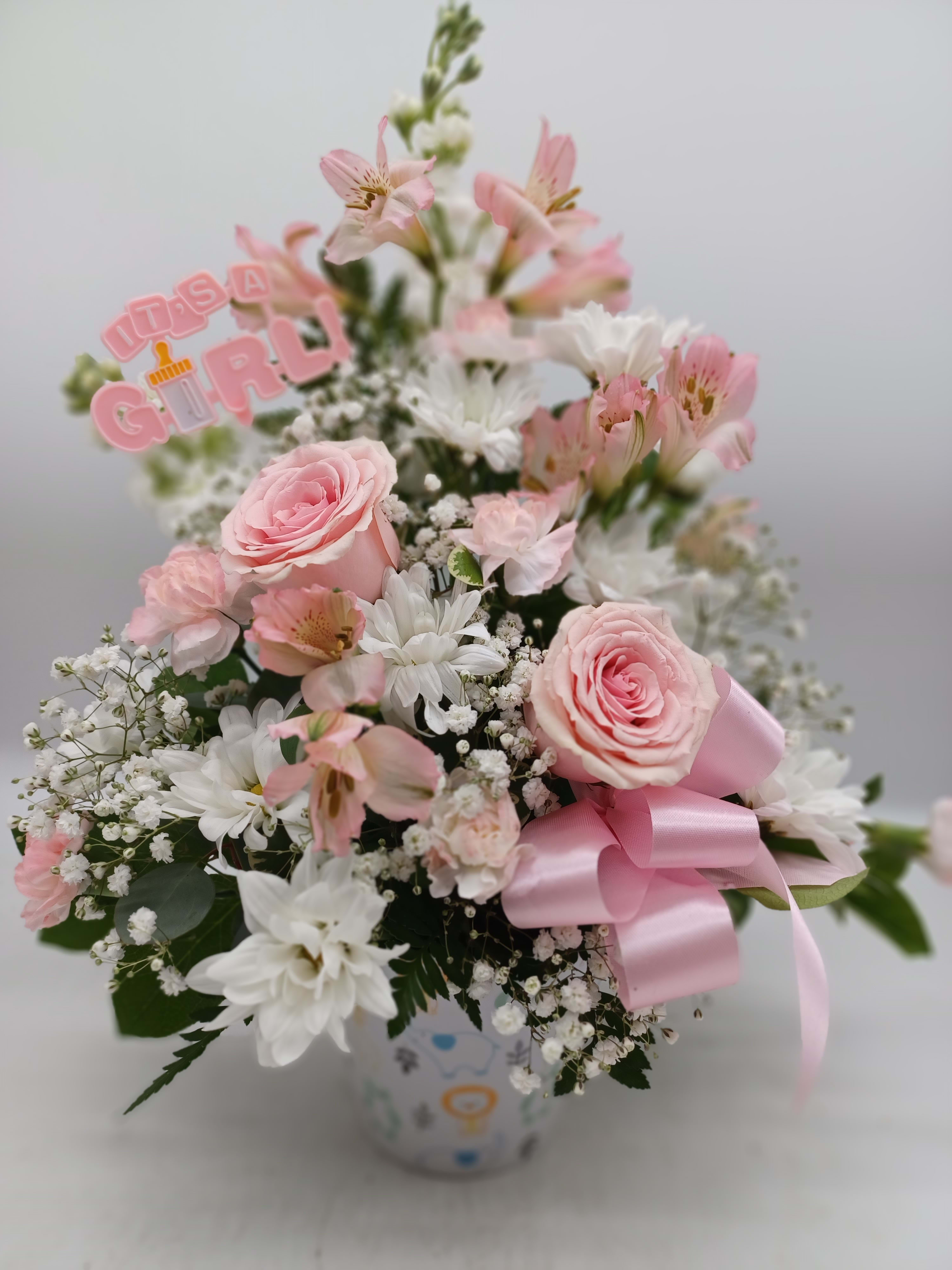 Pink and white bouquet in a vase with a pink ribbon and "It's a Girl" topper