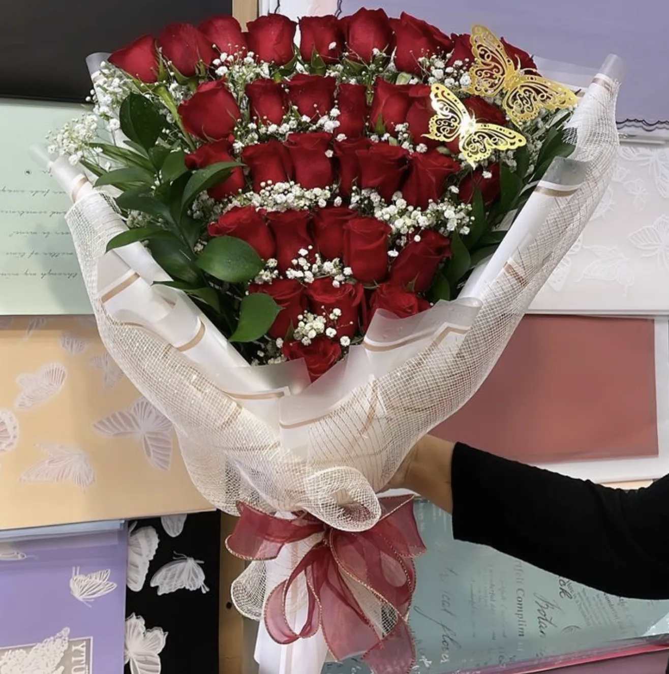 Bouquet of red roses with baby's breath and butterfly accents