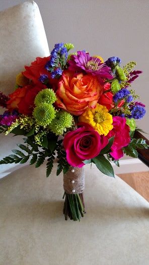 Bright Bursts Clutch Bouquet - This gorgeous clutch bouquet is made up of the freshest seasonal flowers. Flower types may vary depending on the time of year but colors will be the same. Plain Dress? This is the bouquet for you!